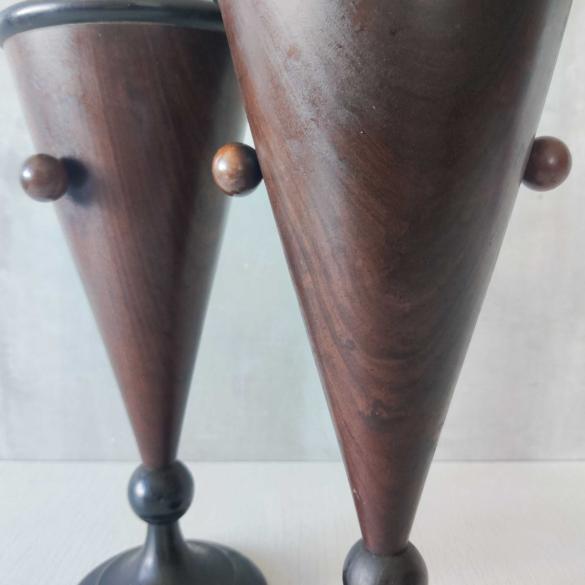A pair of Art Deco turned walnut conical vessels with ebonised trim