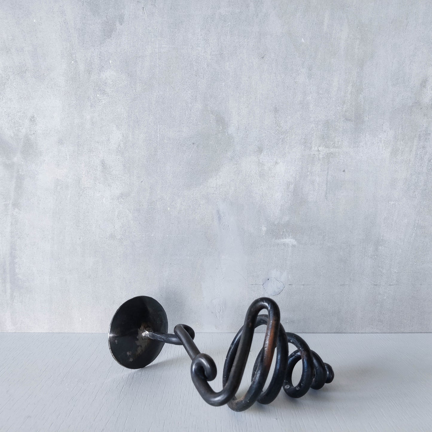 A blacksmith made wrought iron sculptural candle holder