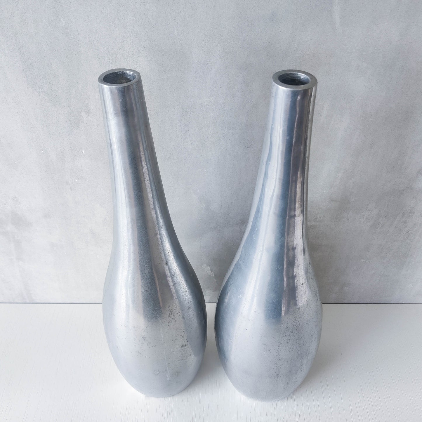 Pair of vintage cast aluminium modernist style sculptural bottles vases vessels 41cms