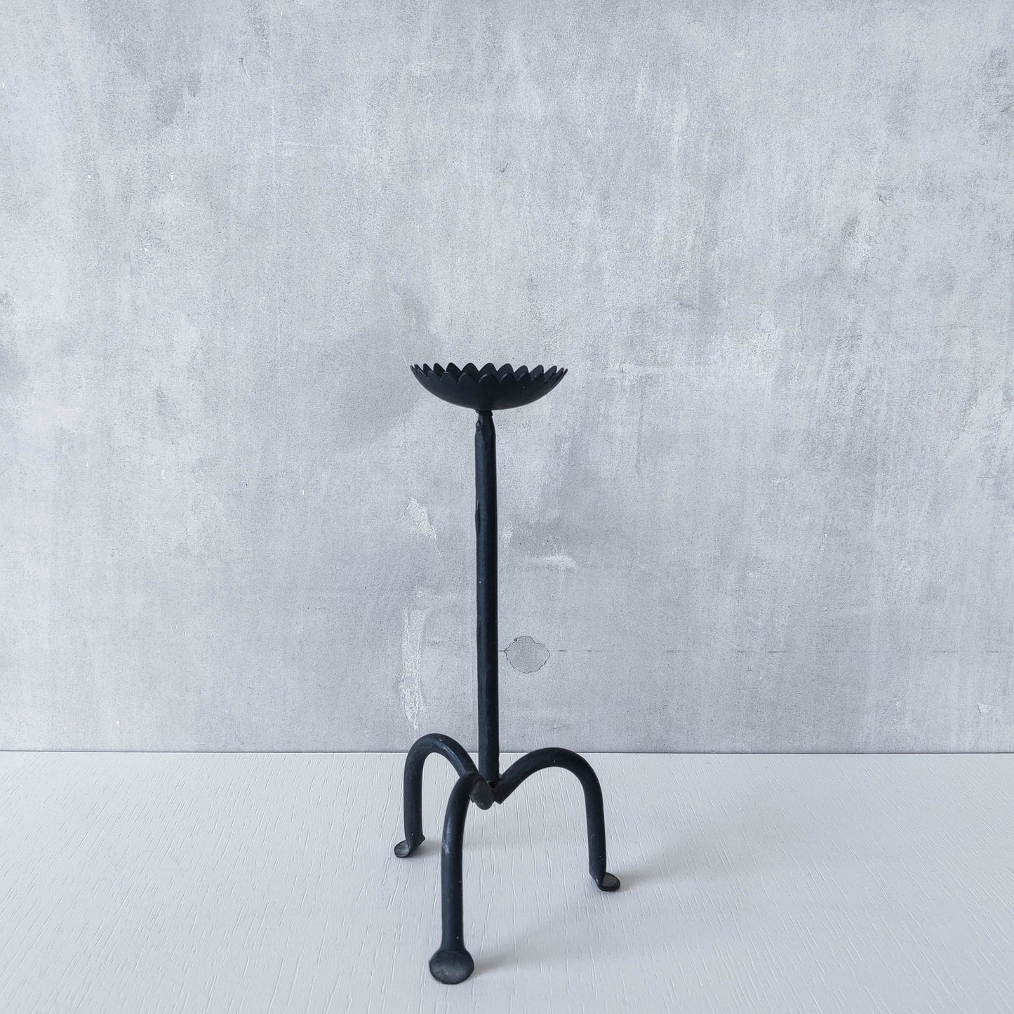 Hand forged black iron sculptural candle holder with scalloped edge tripod feet