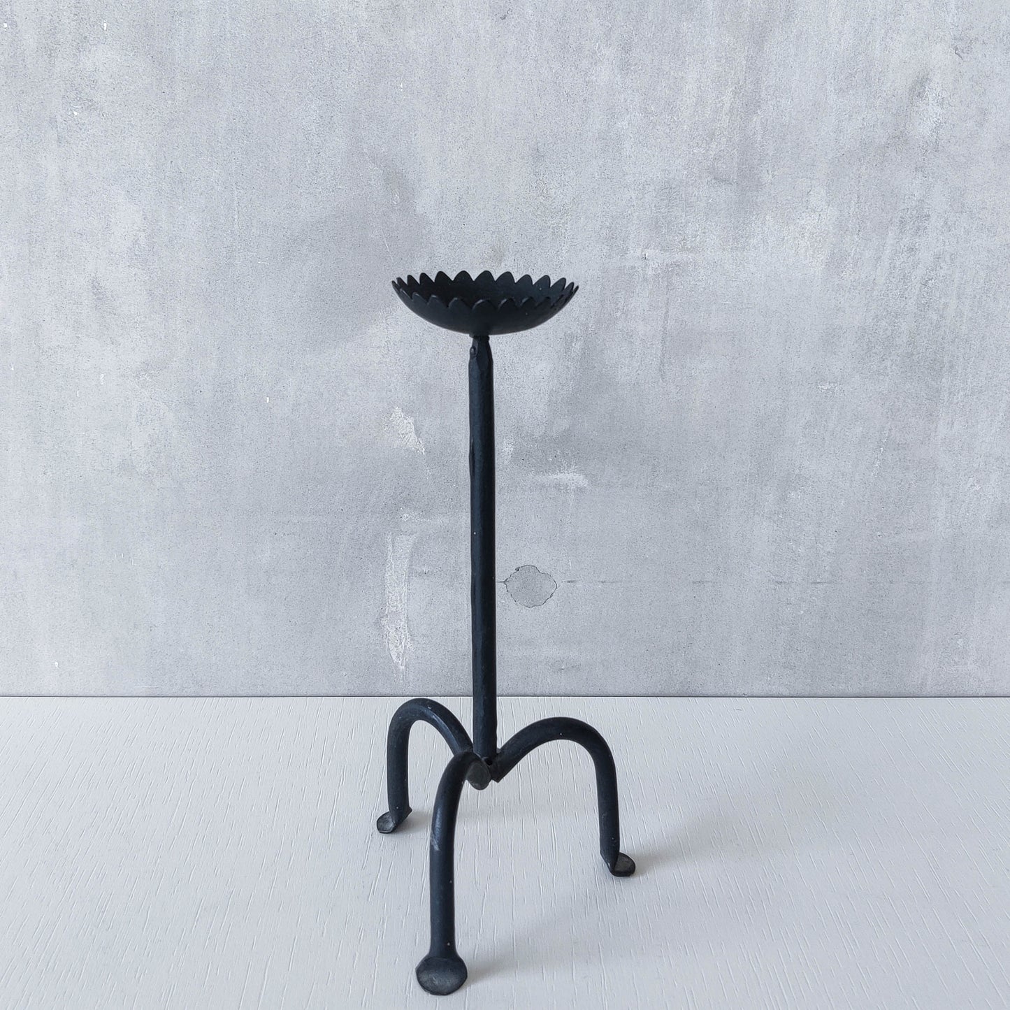 Hand forged black iron sculptural candle holder with scalloped edge tripod feet