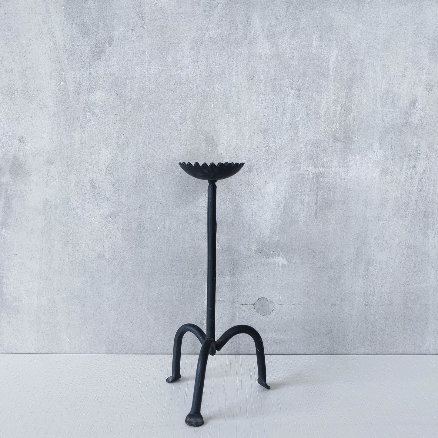 Hand forged black iron sculptural candle holder with scalloped edge tripod feet
