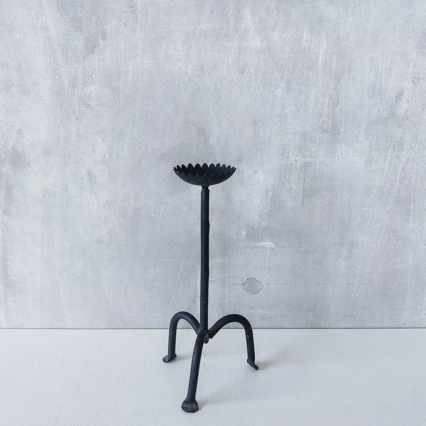 Hand forged black iron sculptural candle holder with scalloped edge tripod feet