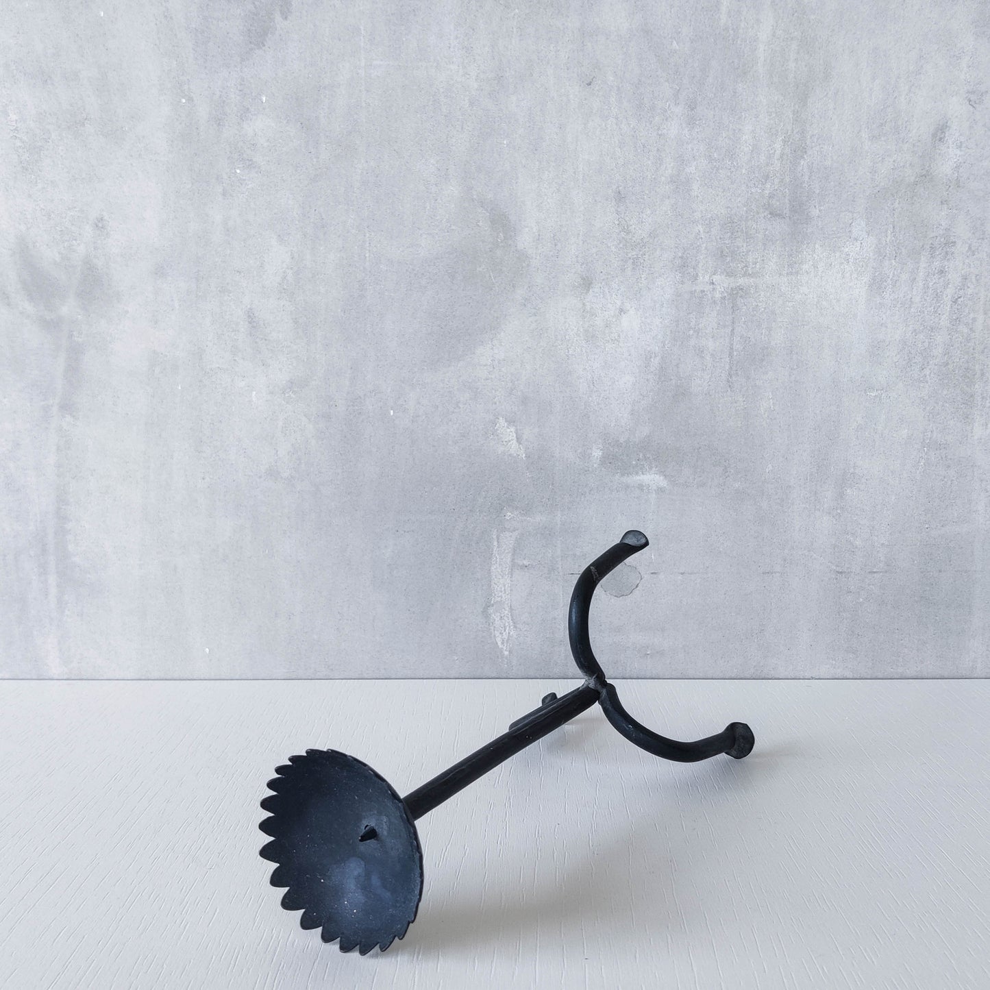 Hand forged black iron sculptural candle holder with scalloped edge tripod feet