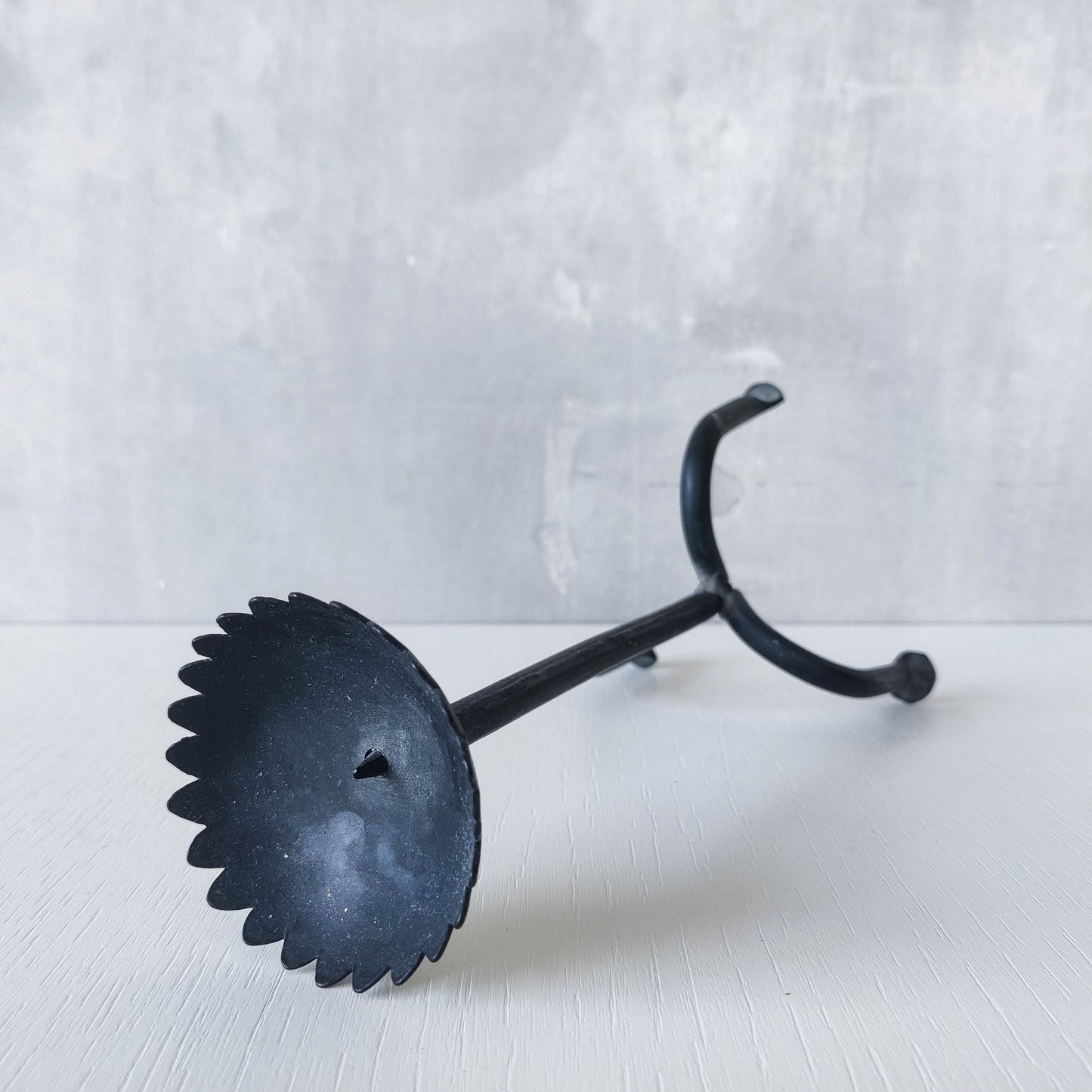 Hand forged black iron sculptural candle holder with scalloped edge tripod feet