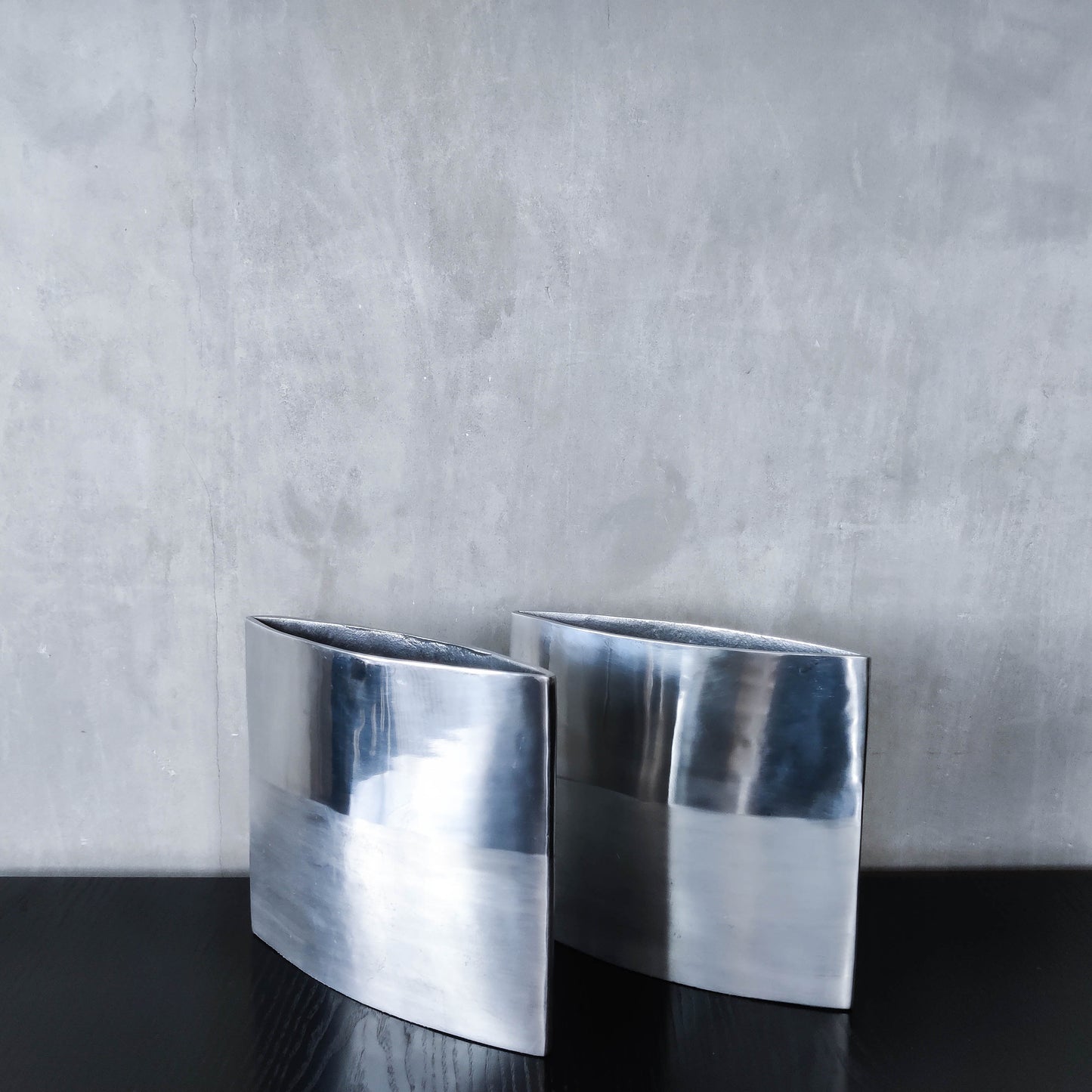 Pair of vintage 00s flat sculptural hand cast aluminium vases