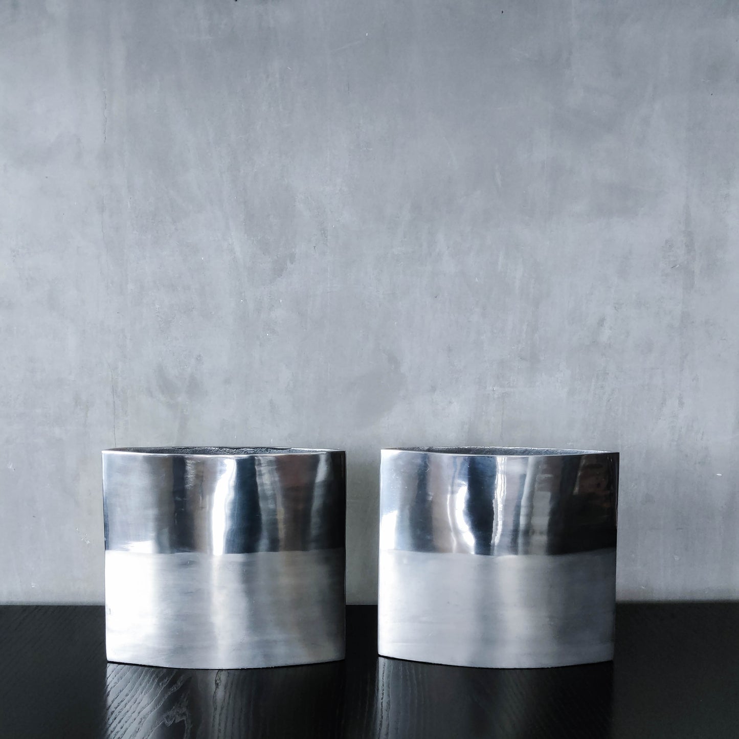 Pair of vintage 00s flat sculptural hand cast aluminium vases