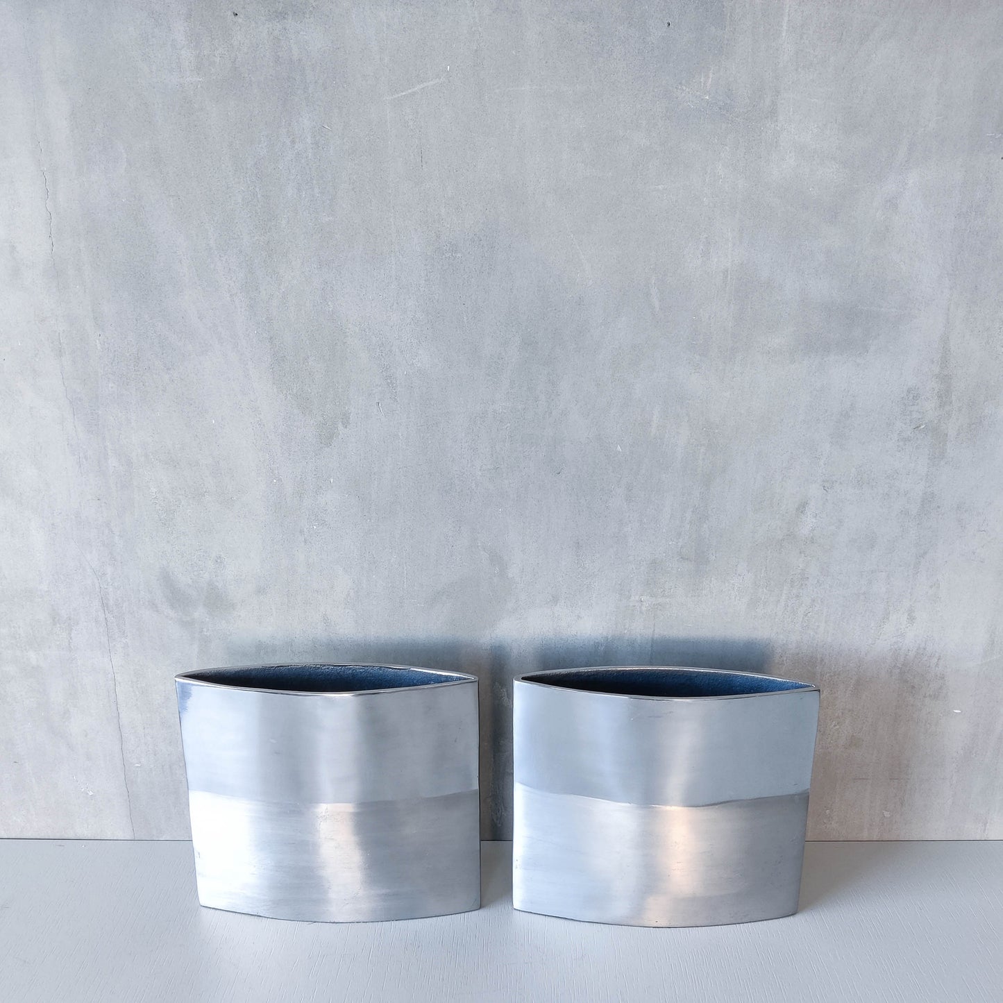 Pair of vintage 00s flat sculptural hand cast aluminium vases