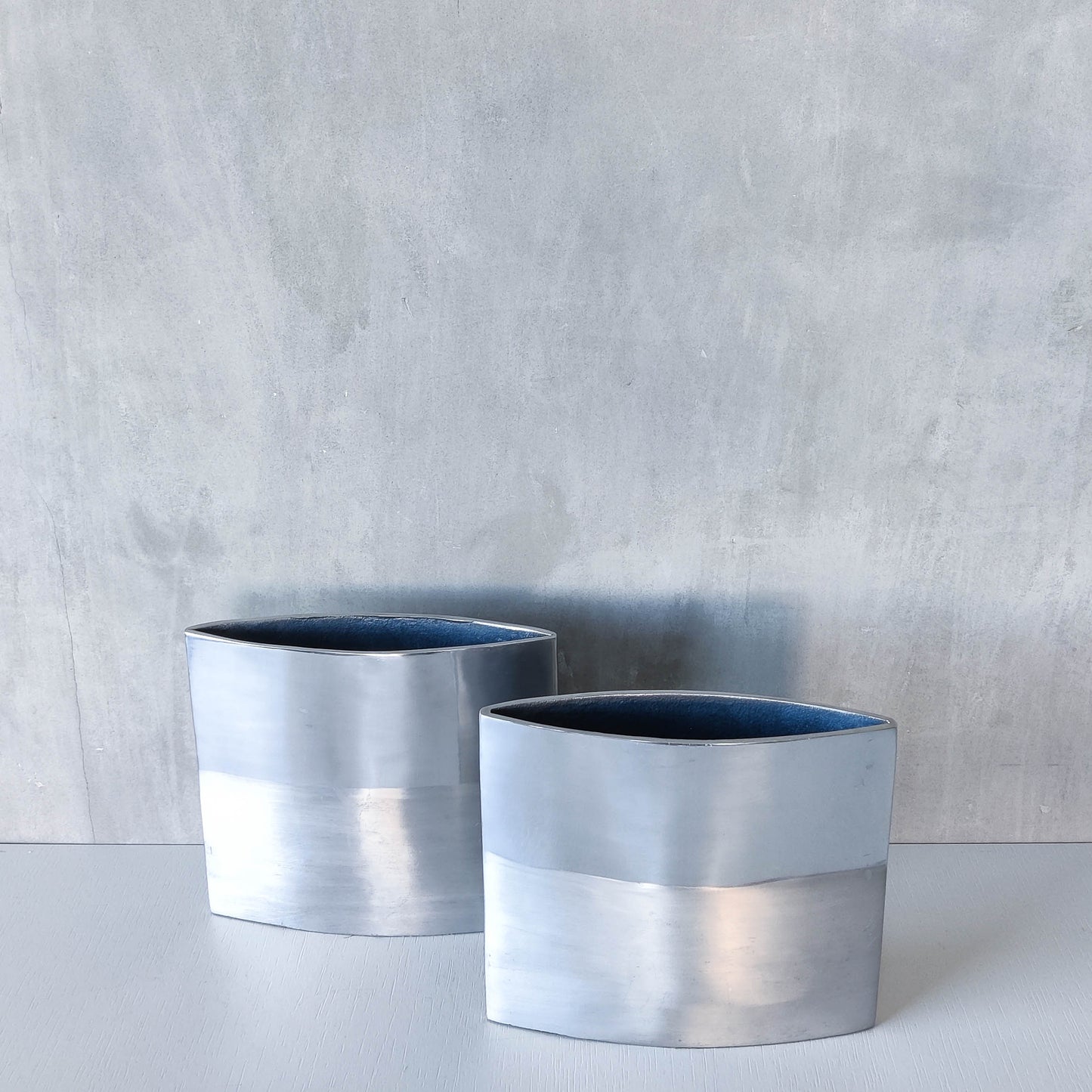 Pair of vintage 00s flat sculptural hand cast aluminium vases