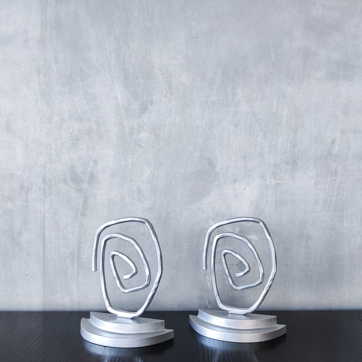 Vintage 1990s post modern style silver metal swirl spiral weighted bookends pair