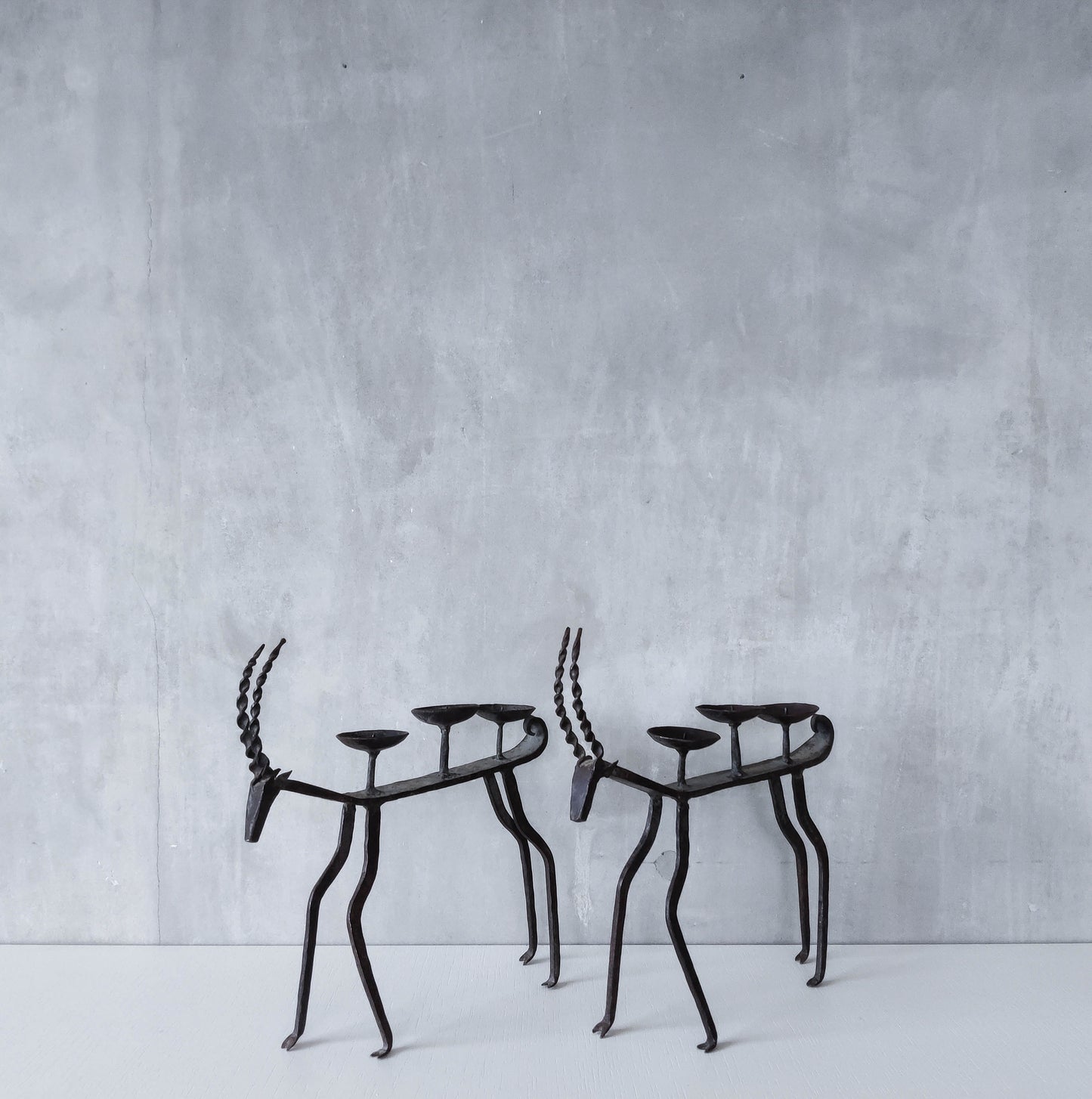 Pair of brutalist vintage wrought iron primitive antelope deer candelabras