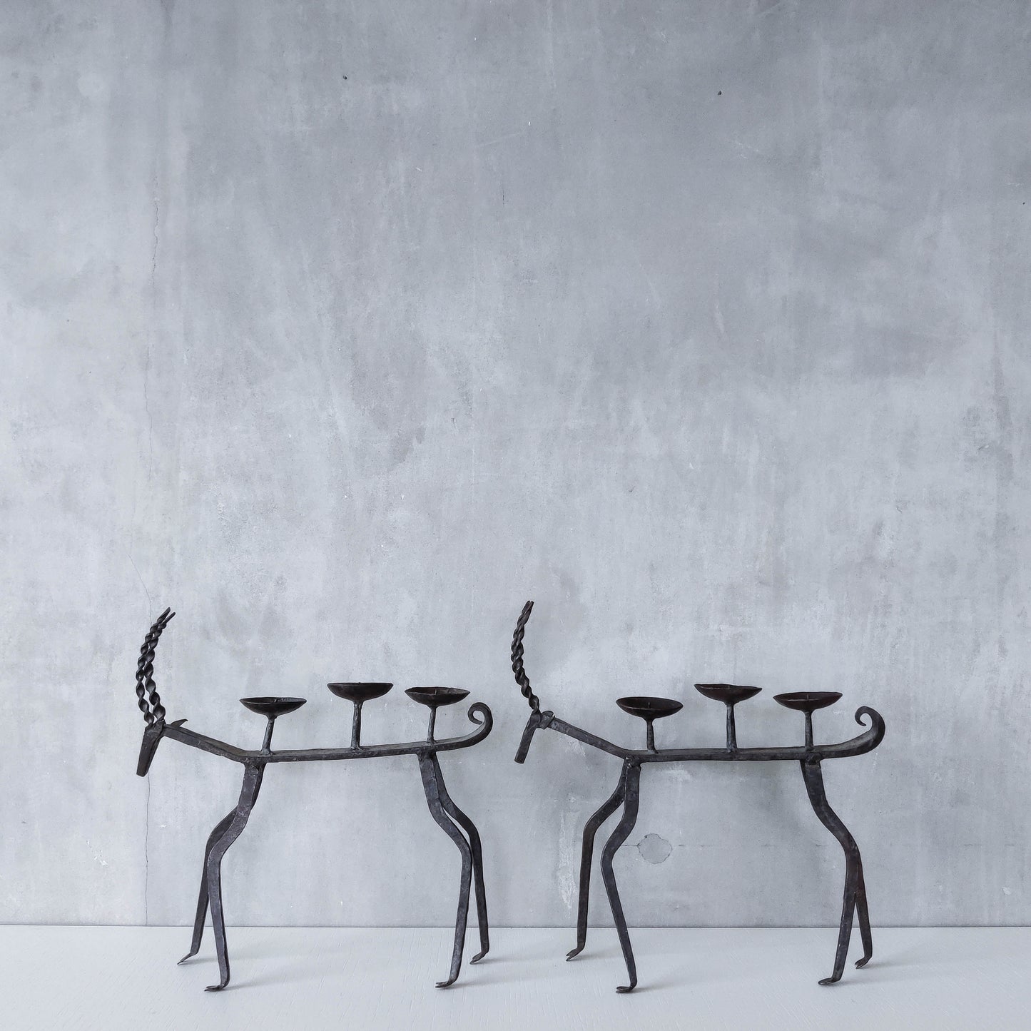 Pair of brutalist vintage wrought iron primitive antelope deer candelabras