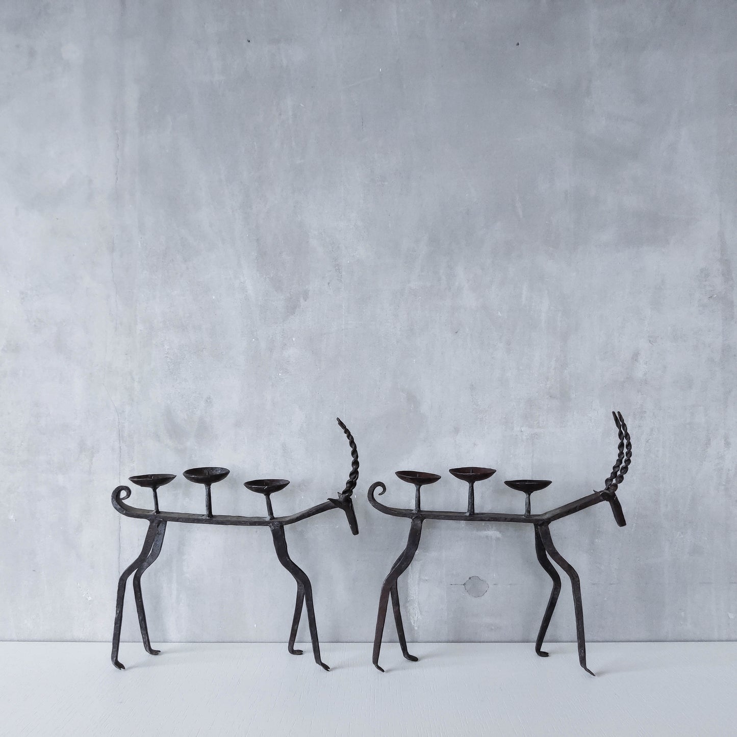 Pair of brutalist vintage wrought iron primitive antelope deer candelabras