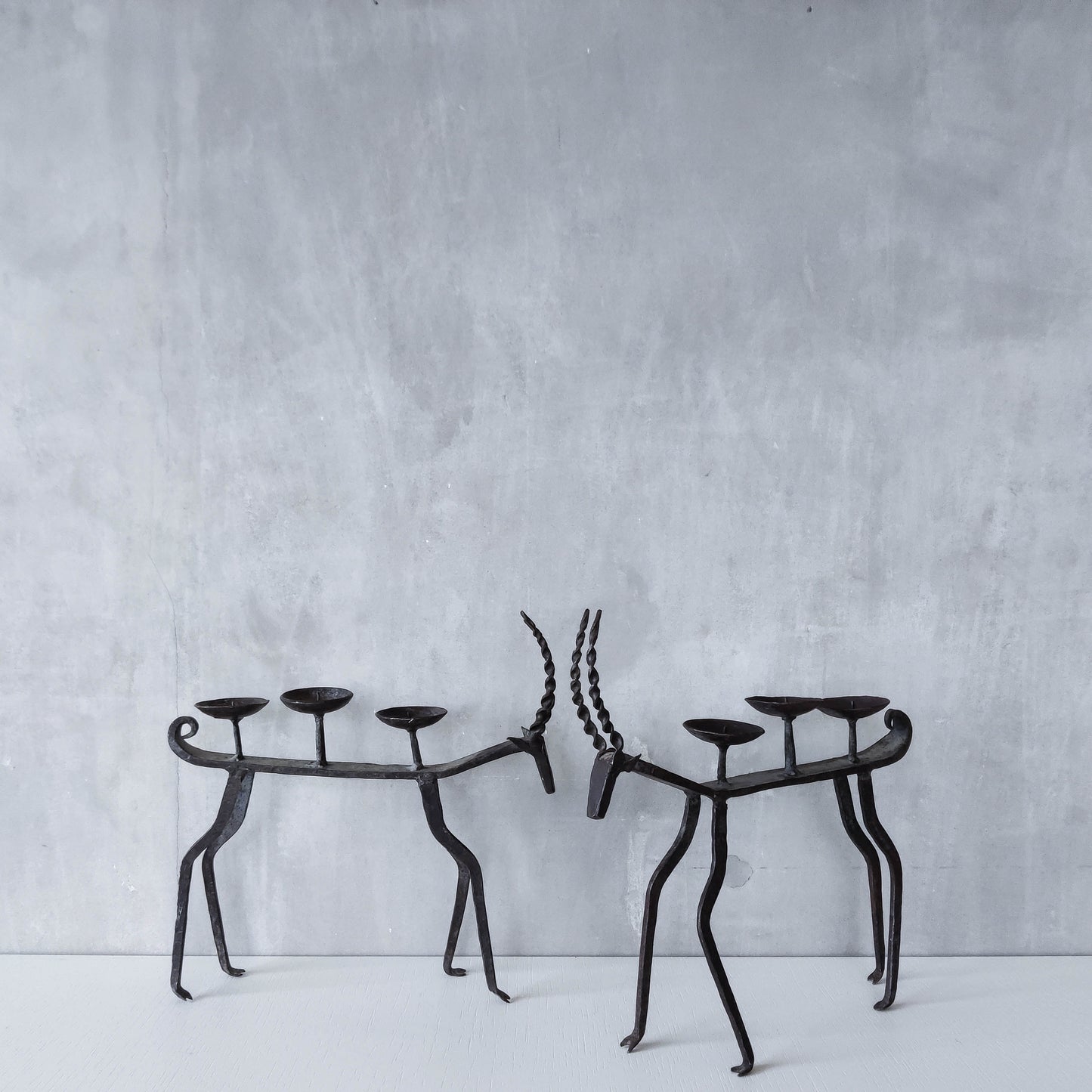 Pair of brutalist vintage wrought iron primitive antelope deer candelabras