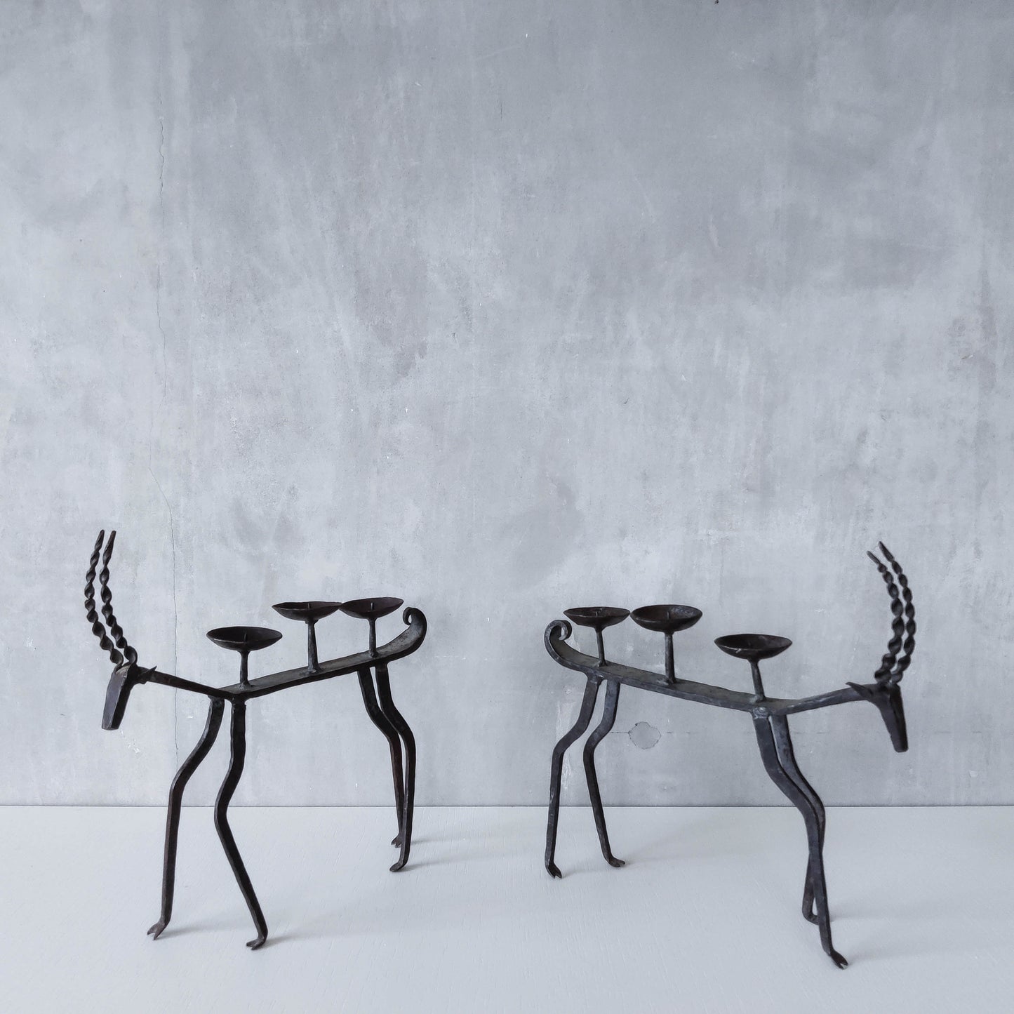 Pair of brutalist vintage wrought iron primitive antelope deer candelabras