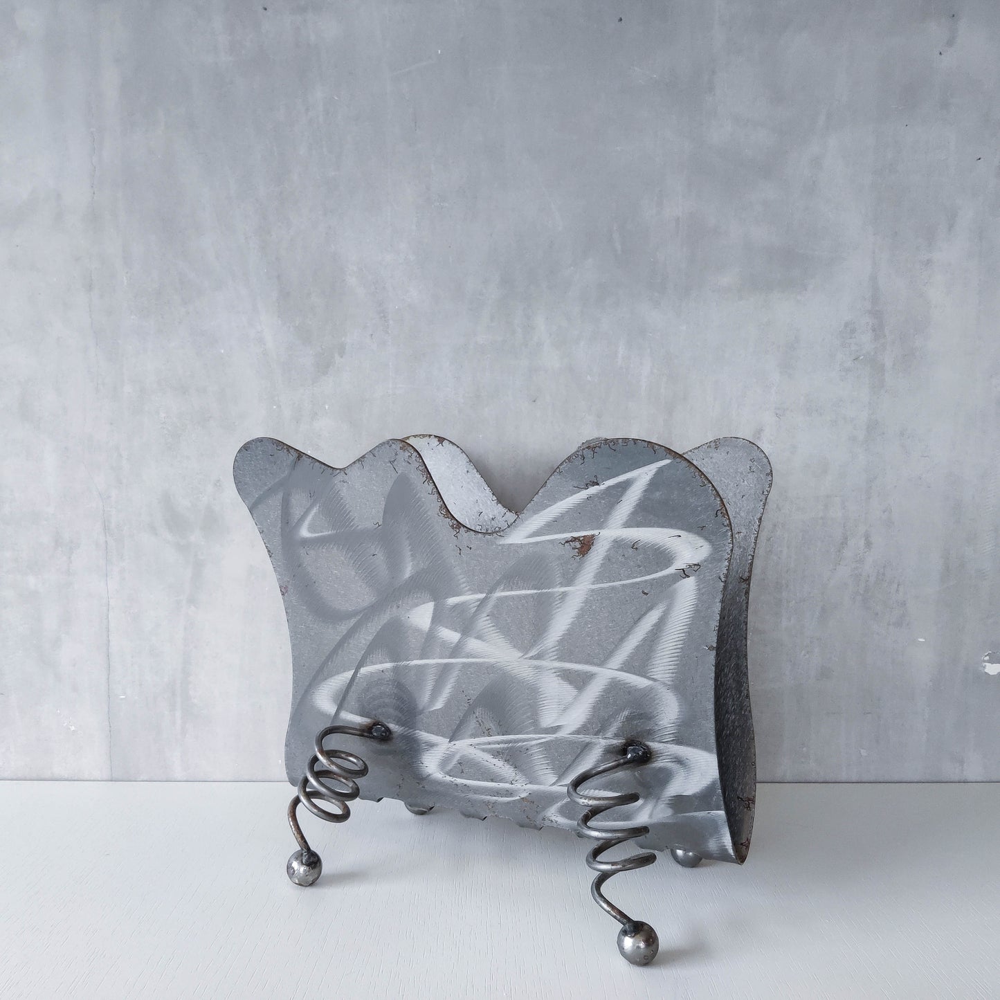 Vintage 1990s postmodern welded steel sculptural magazine rack with spiral ball feet