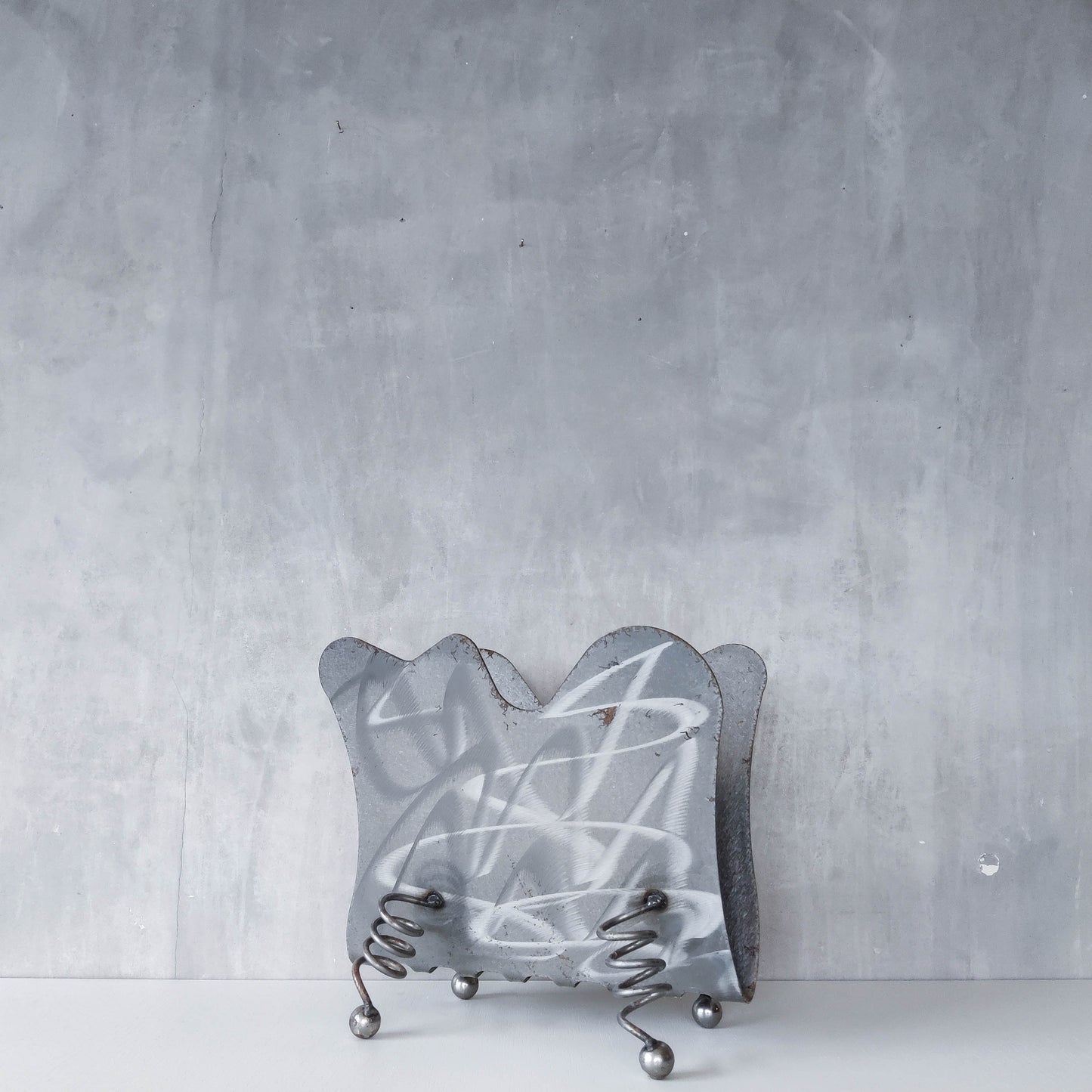 Vintage 1990s postmodern welded steel sculptural magazine rack with spiral ball feet