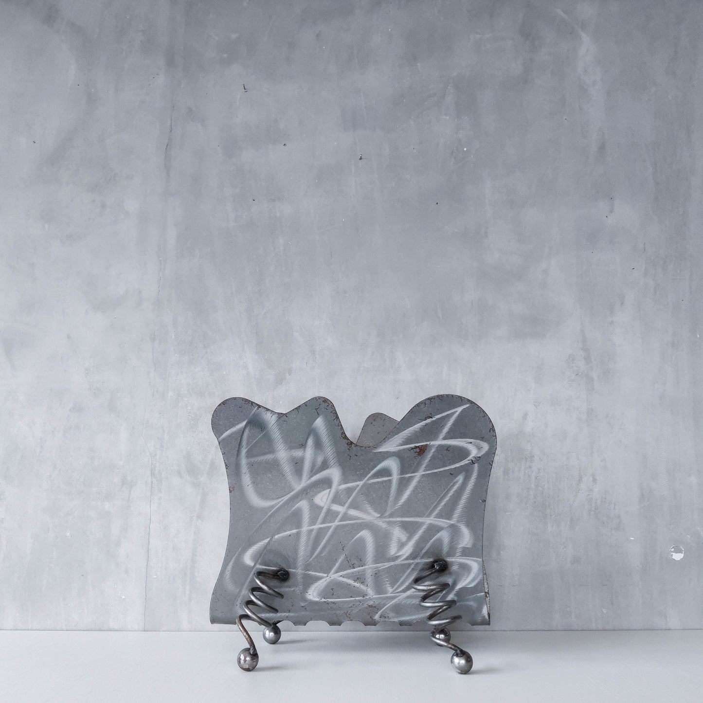 Vintage 1990s postmodern welded steel sculptural magazine rack with spiral ball feet