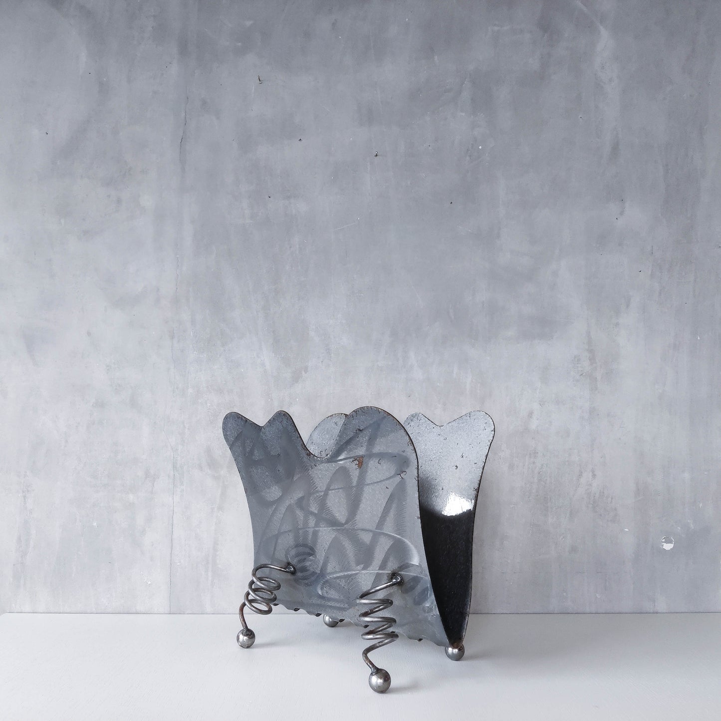 Vintage 1990s postmodern welded steel sculptural magazine rack with spiral ball feet