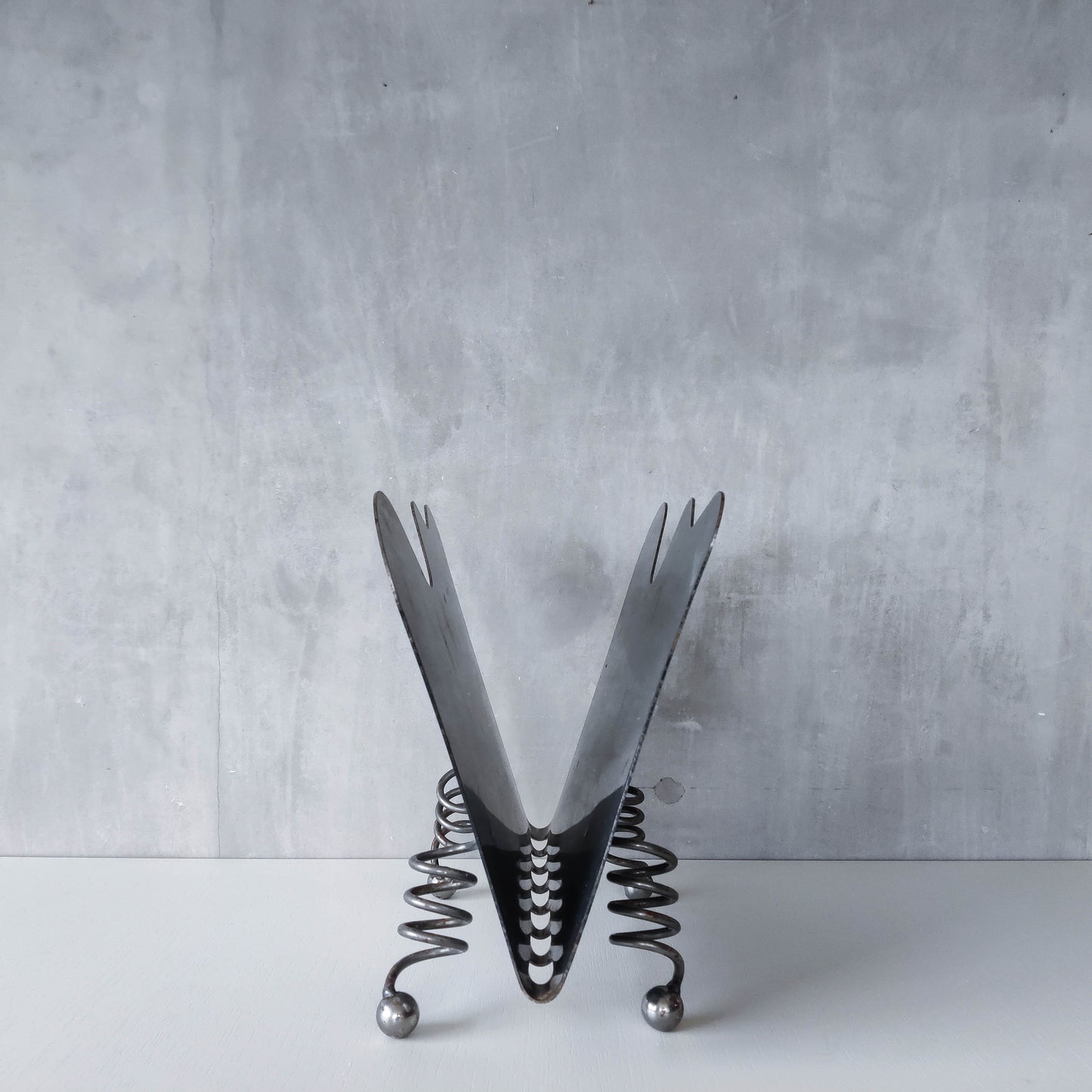 Vintage 1990s postmodern welded steel sculptural magazine rack with spiral ball feet
