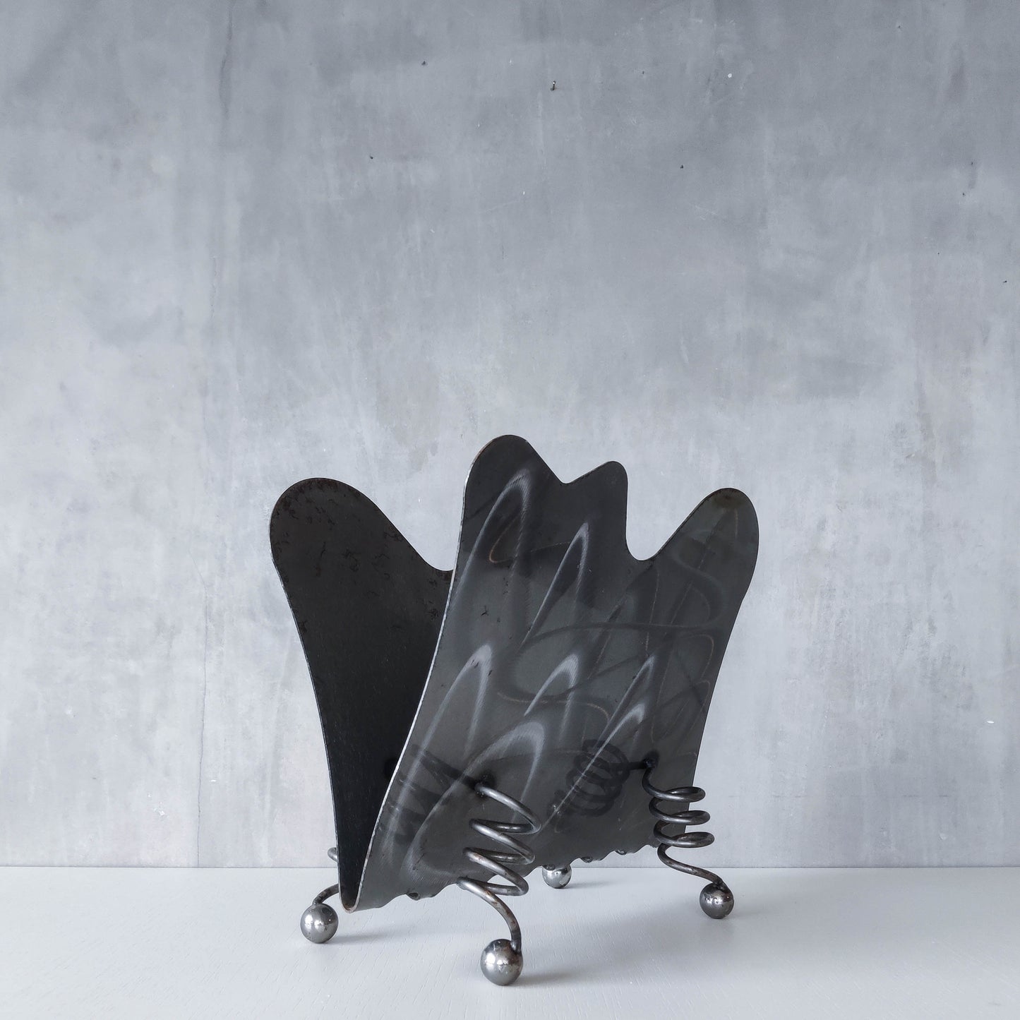 Vintage 1990s postmodern welded steel sculptural magazine rack with spiral ball feet