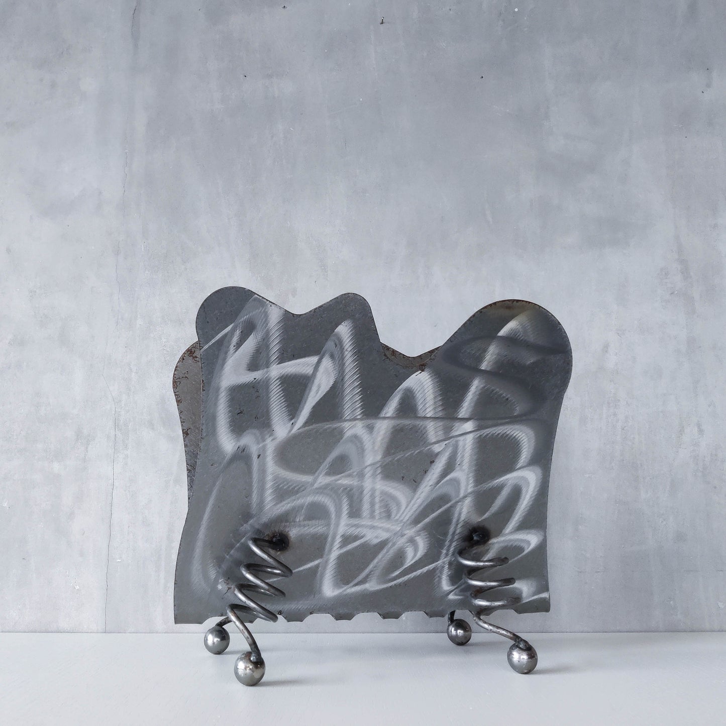 Vintage 1990s postmodern welded steel sculptural magazine rack with spiral ball feet