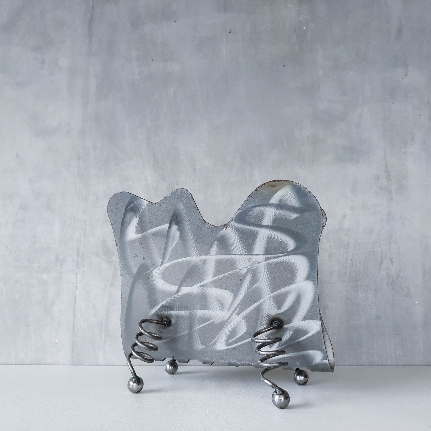 Vintage 1990s postmodern welded steel sculptural magazine rack with spiral ball feet