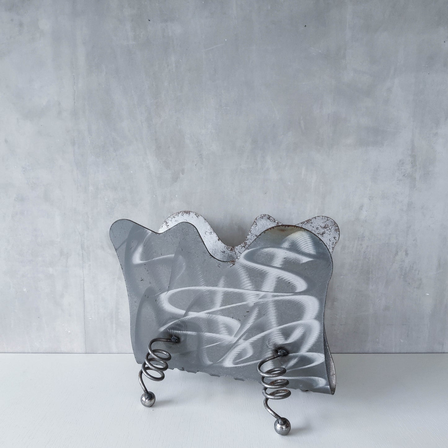 Vintage 1990s postmodern welded steel sculptural magazine rack with spiral ball feet