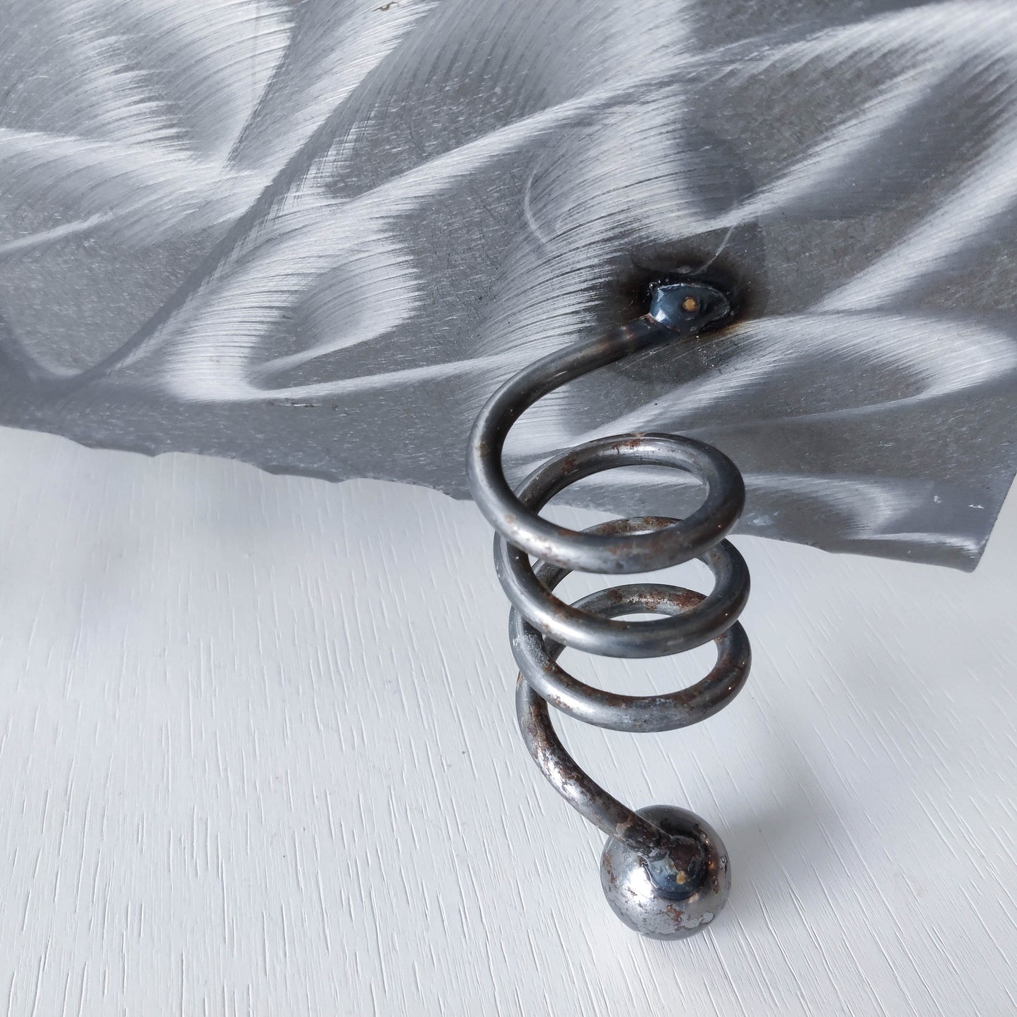 Vintage 1990s postmodern welded steel sculptural magazine rack with spiral ball feet