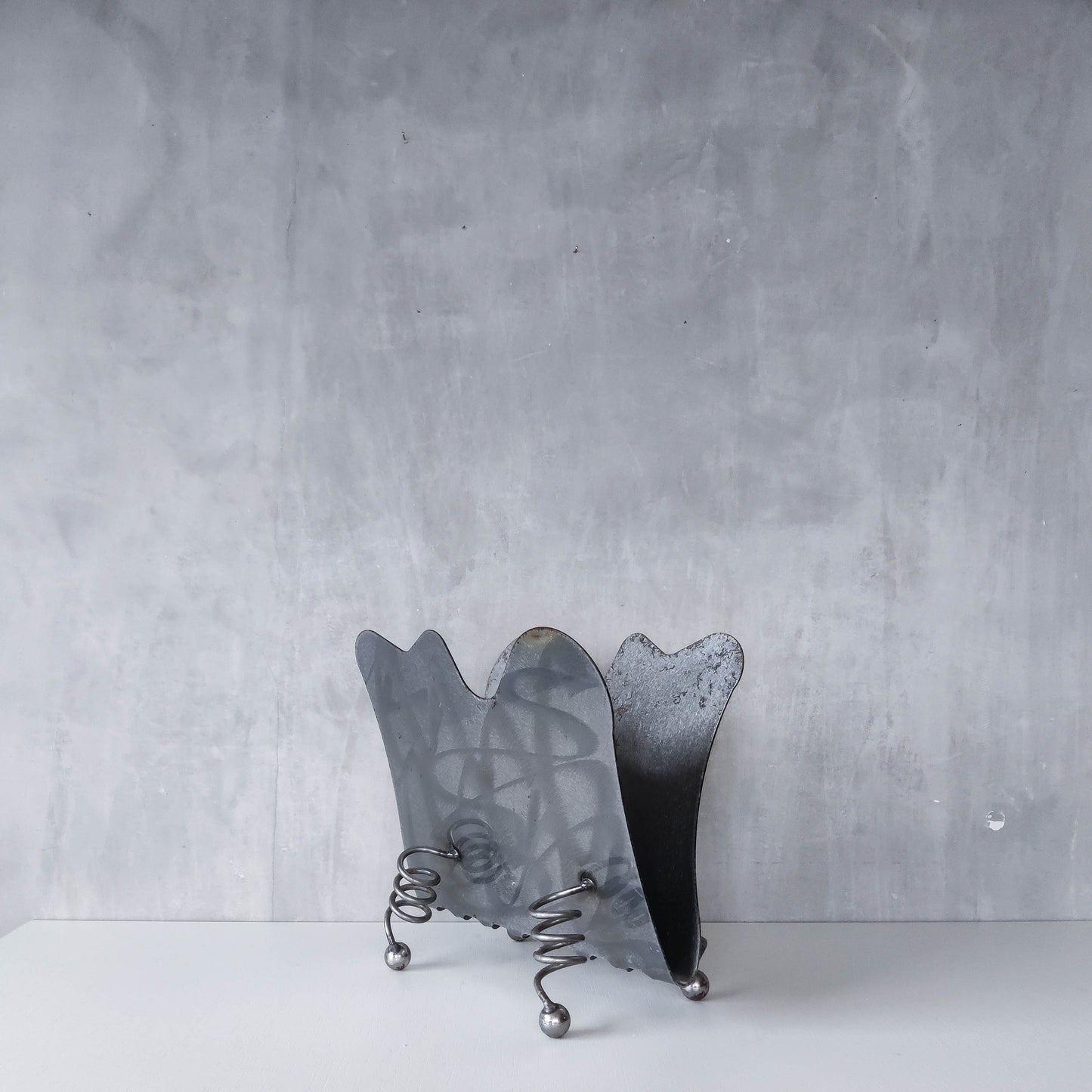 Vintage 1990s postmodern welded steel sculptural magazine rack with spiral ball feet