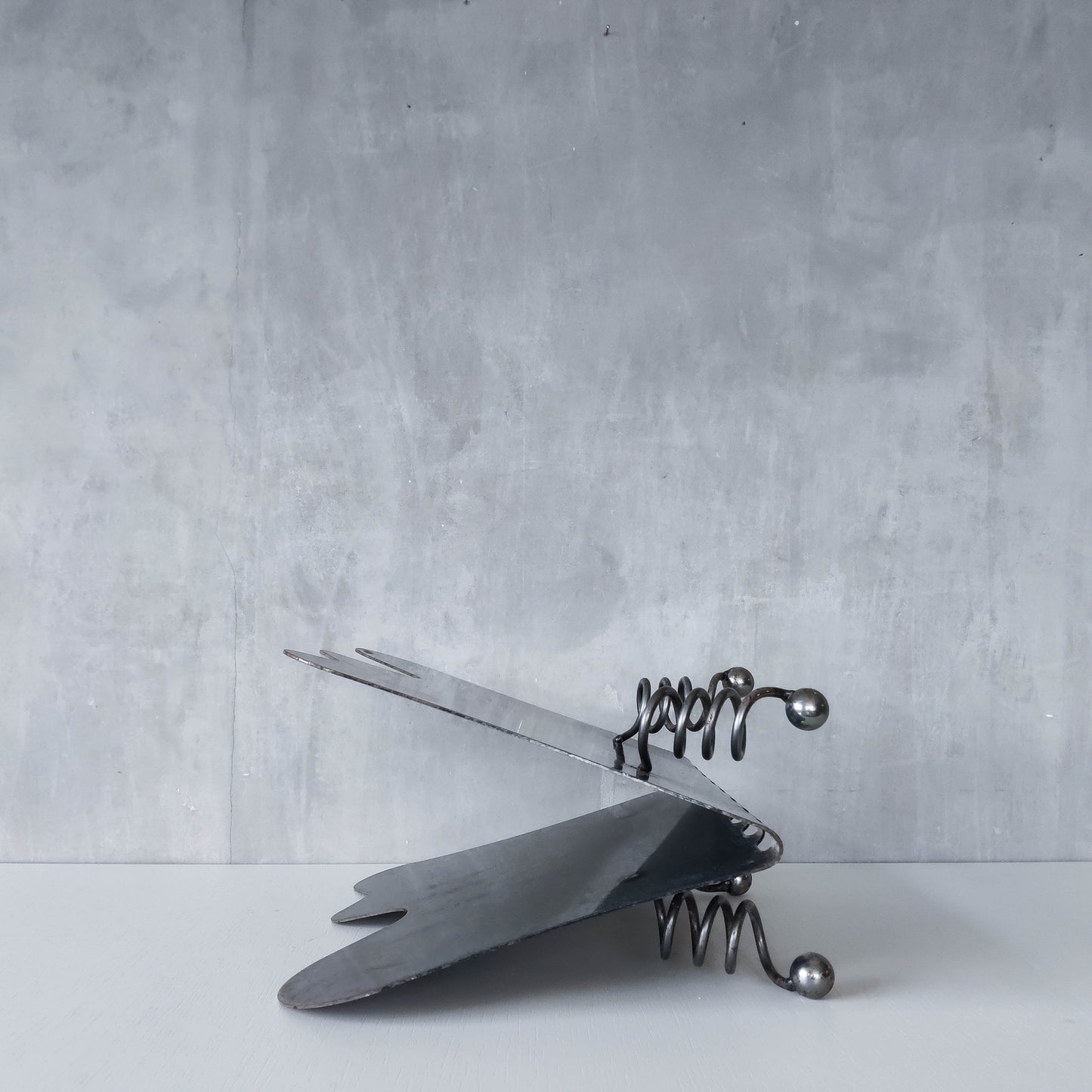 Vintage 1990s postmodern welded steel sculptural magazine rack with spiral ball feet