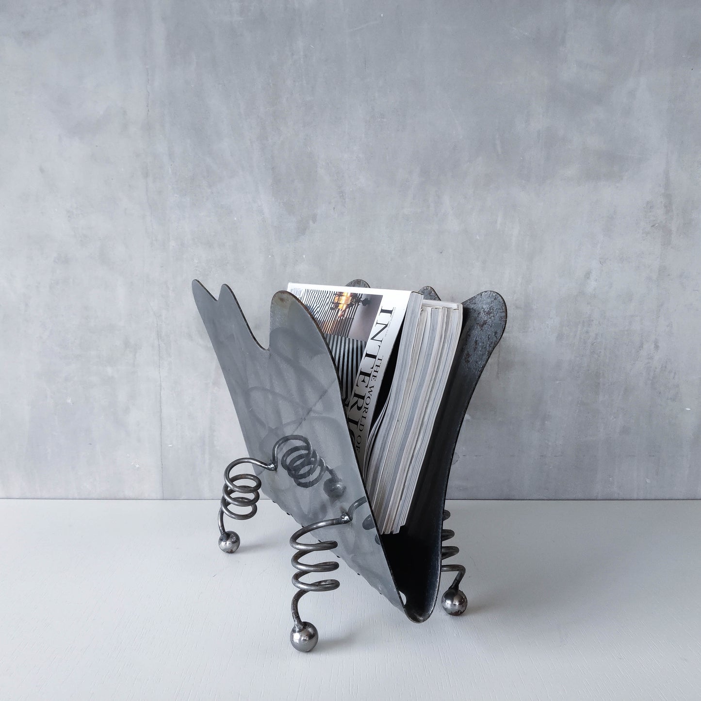 Vintage 1990s postmodern welded steel sculptural magazine rack with spiral ball feet