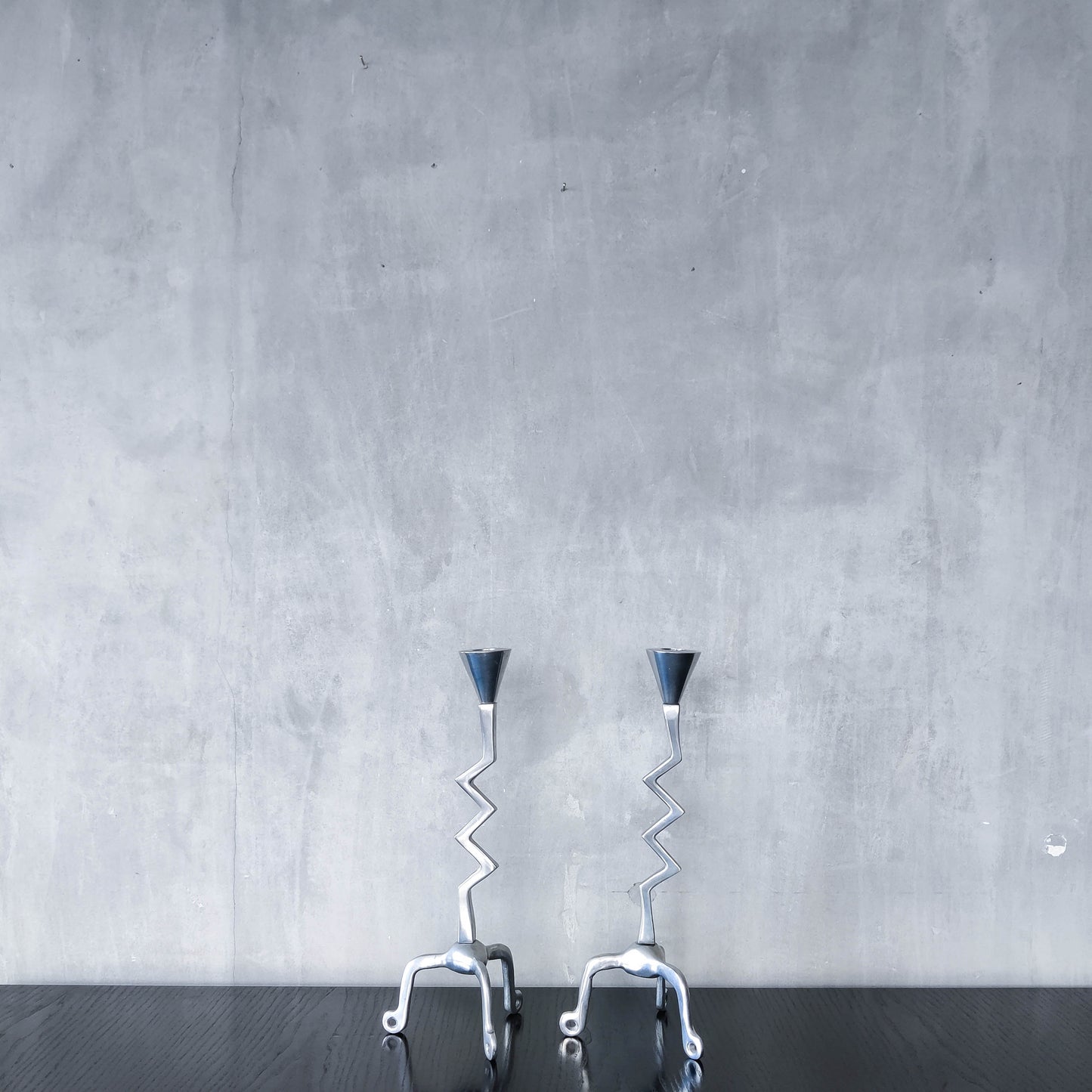 Pair of vintage postmodern chunky sculptural zigzag cast aluminium footed candle holders