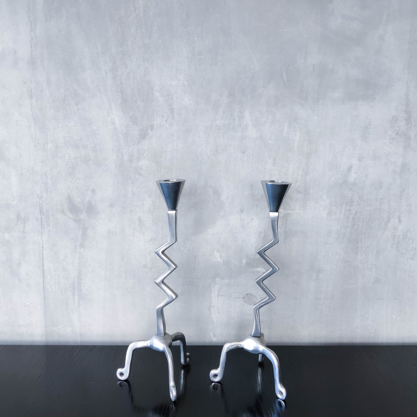 Pair of vintage postmodern chunky sculptural zigzag cast aluminium footed candle holders