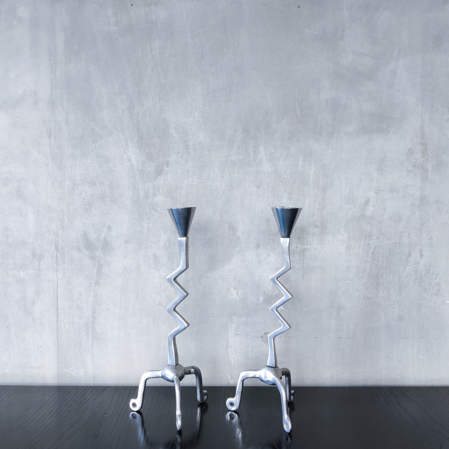 Pair of vintage postmodern chunky sculptural zigzag cast aluminium footed candle holders
