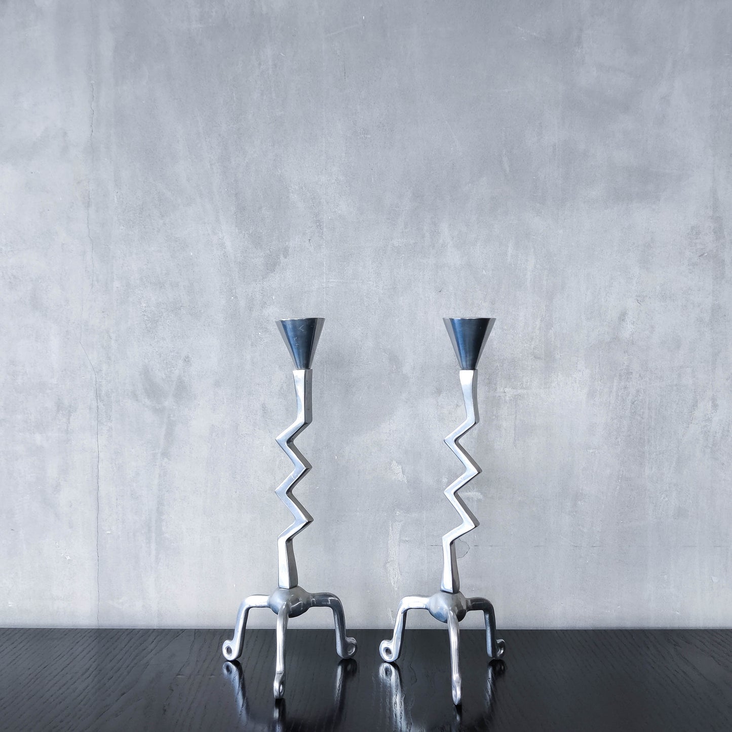 Pair of vintage postmodern chunky sculptural zigzag cast aluminium footed candle holders