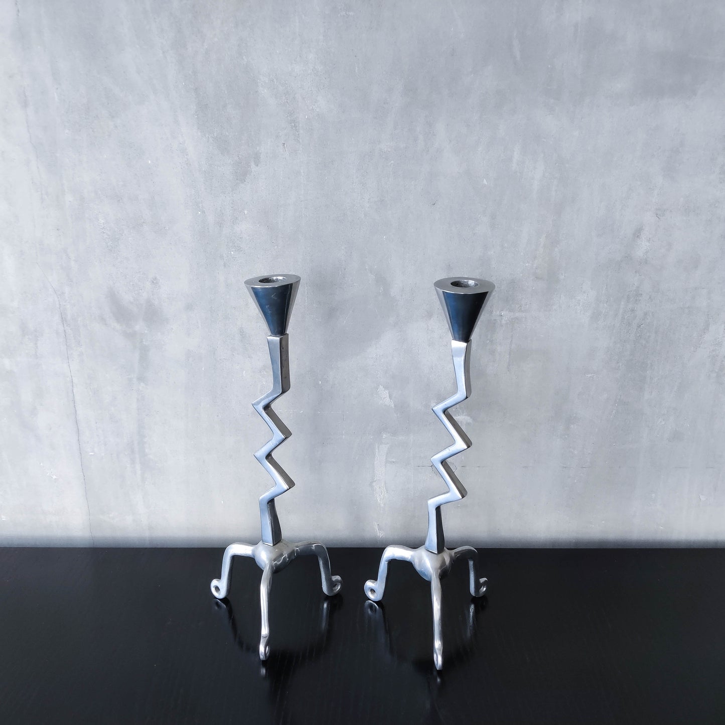 Pair of vintage postmodern chunky sculptural zigzag cast aluminium footed candle holders