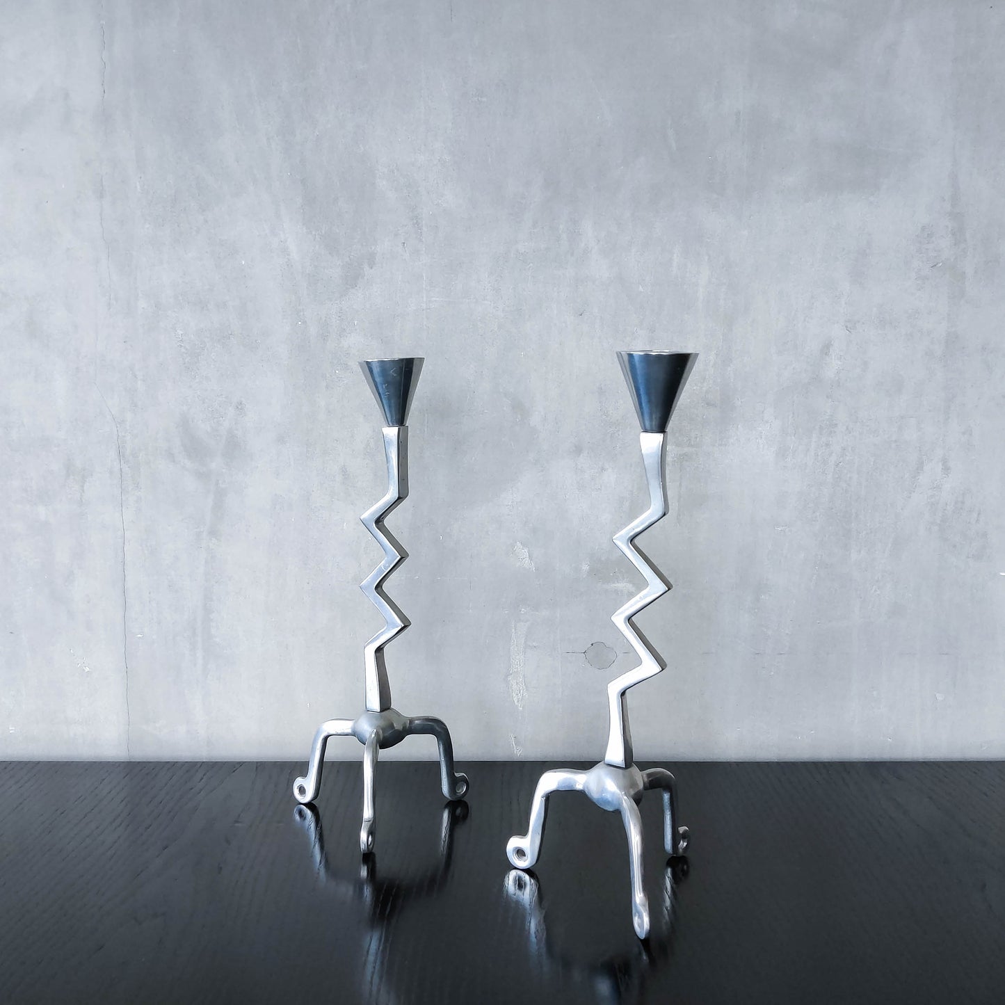 Pair of vintage postmodern chunky sculptural zigzag cast aluminium footed candle holders