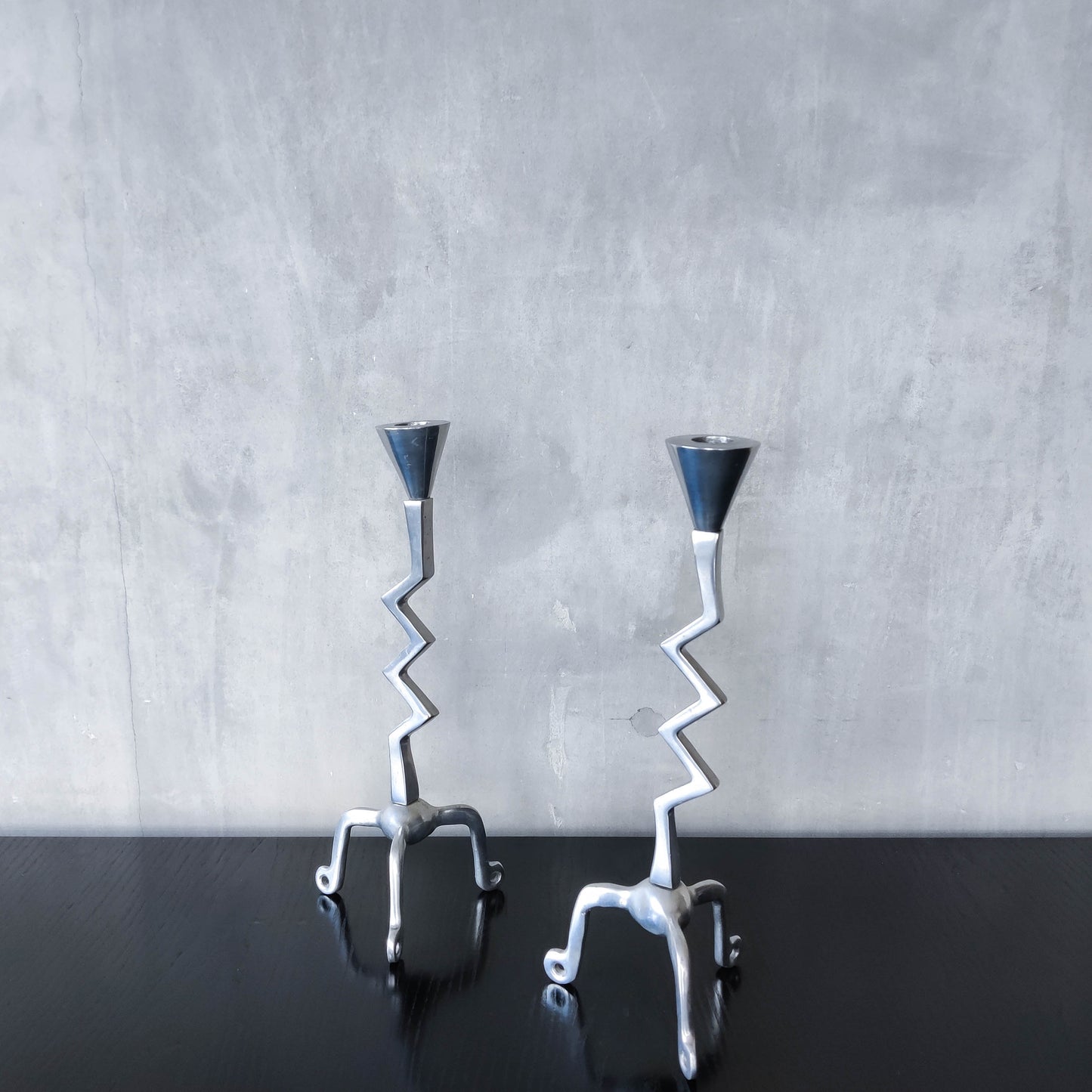 Pair of vintage postmodern chunky sculptural zigzag cast aluminium footed candle holders