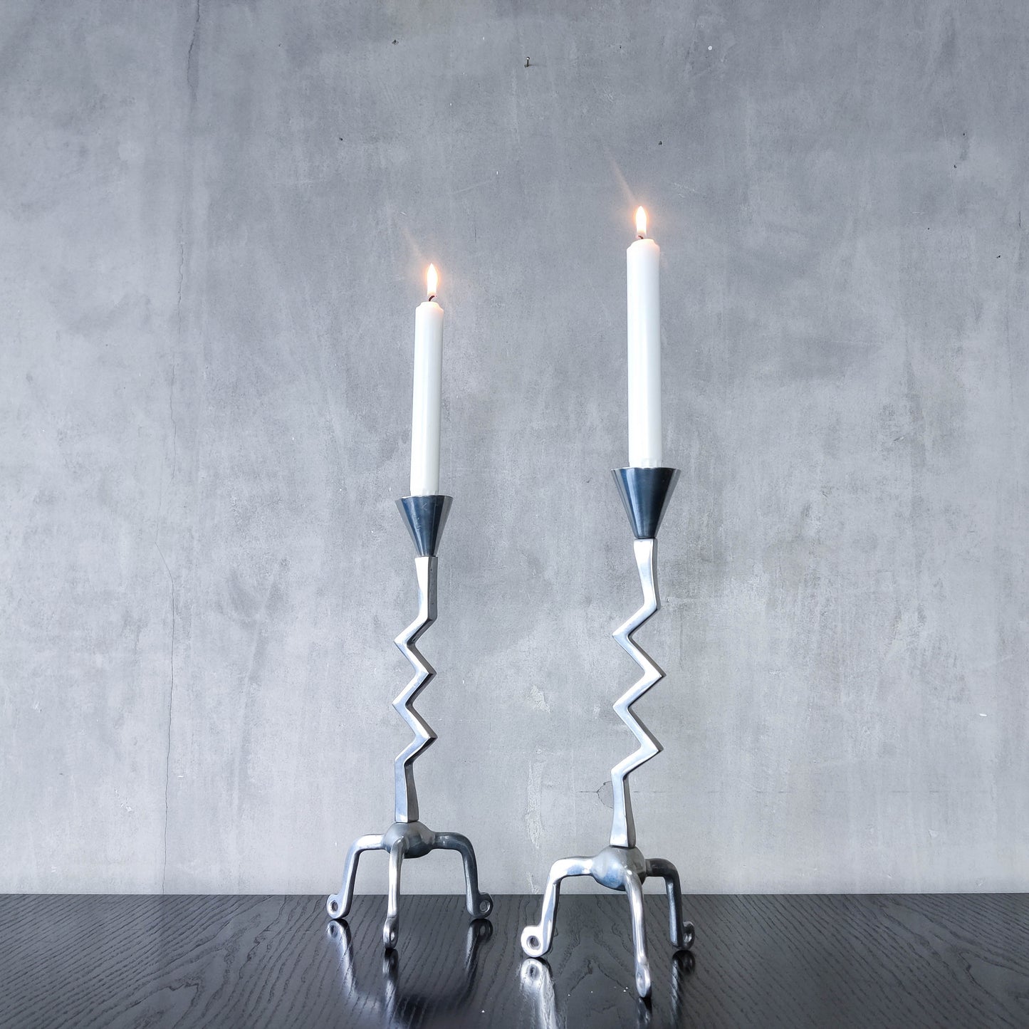 Pair of vintage postmodern chunky sculptural zigzag cast aluminium footed candle holders