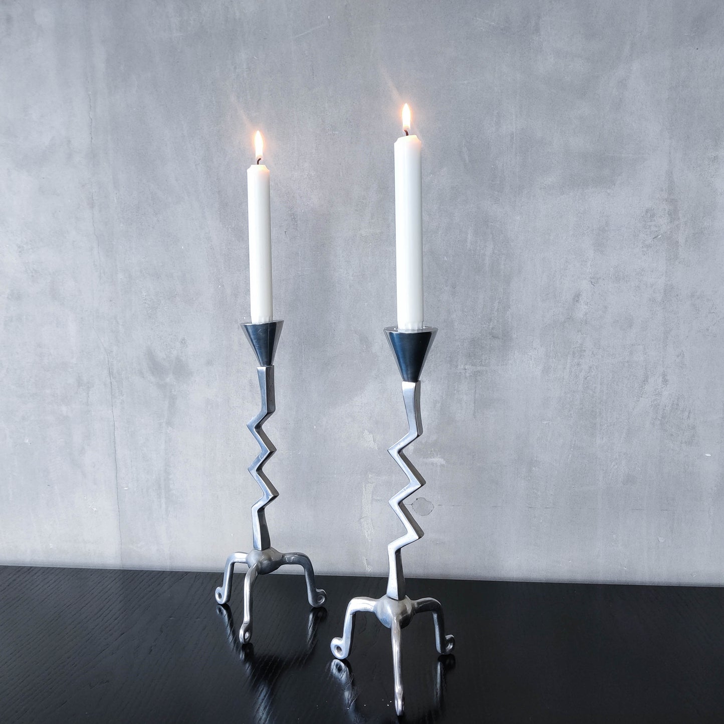 Pair of vintage postmodern chunky sculptural zigzag cast aluminium footed candle holders