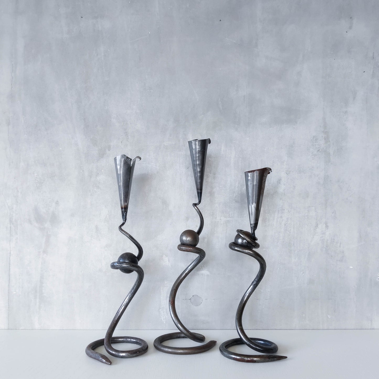 Trio of sculptural handmade wrought iron welded steel candle holders with steel balls