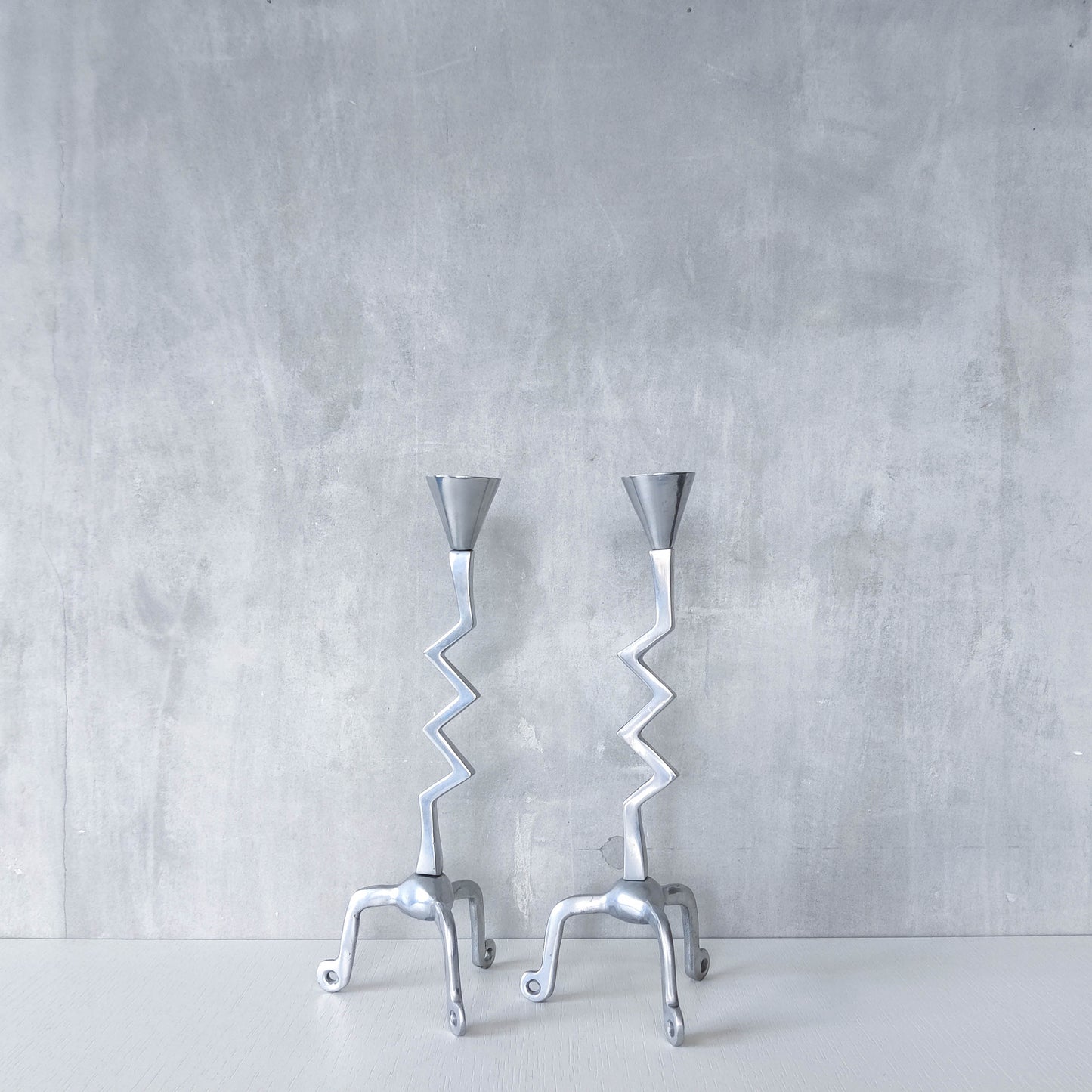 Pair of vintage postmodern chunky sculptural zigzag cast aluminium footed candle holders