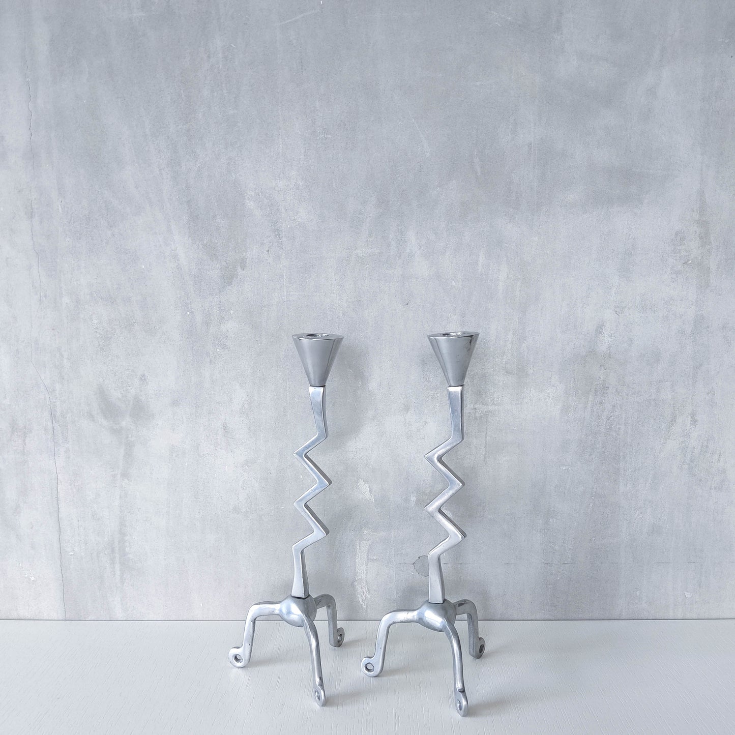 Pair of vintage postmodern chunky sculptural zigzag cast aluminium footed candle holders