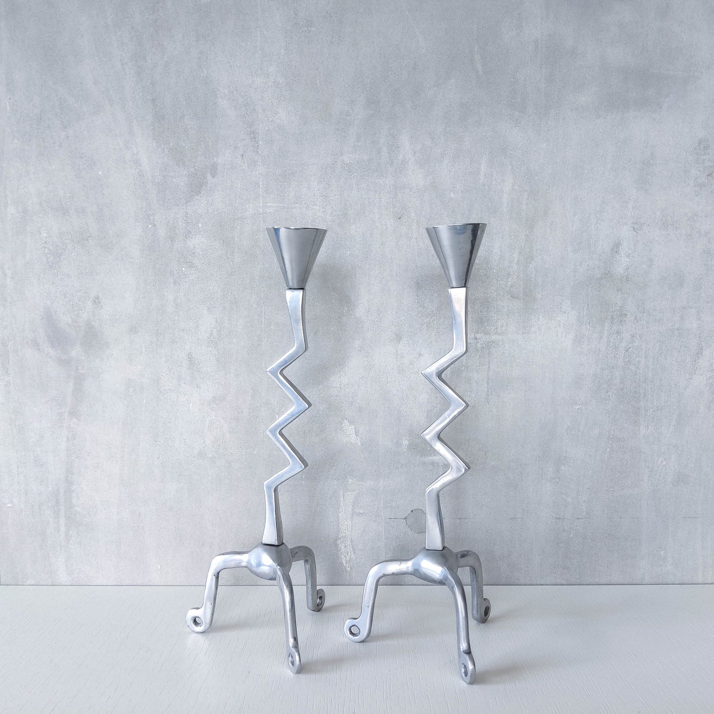 Pair of vintage postmodern chunky sculptural zigzag cast aluminium footed candle holders