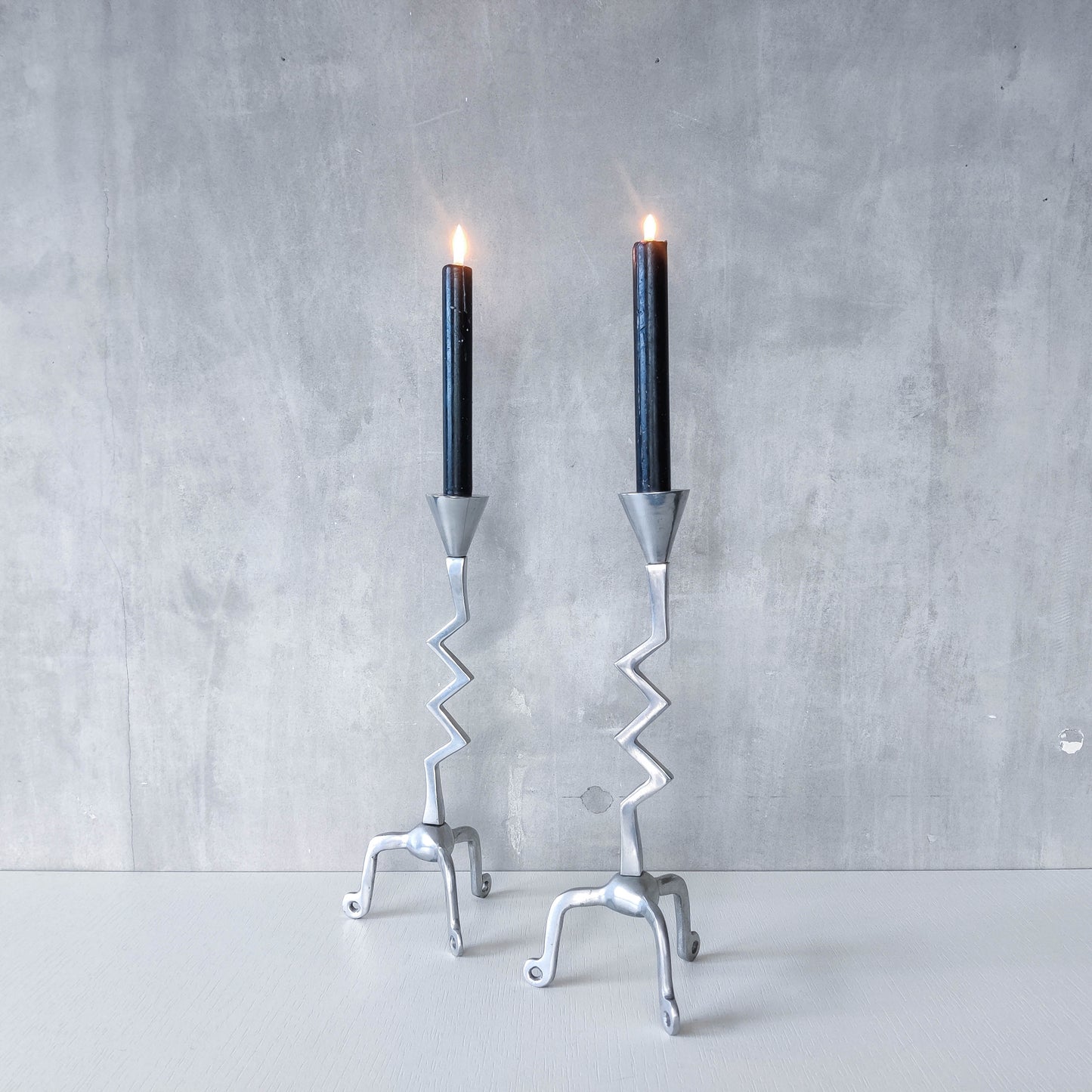 Pair of vintage postmodern chunky sculptural zigzag cast aluminium footed candle holders
