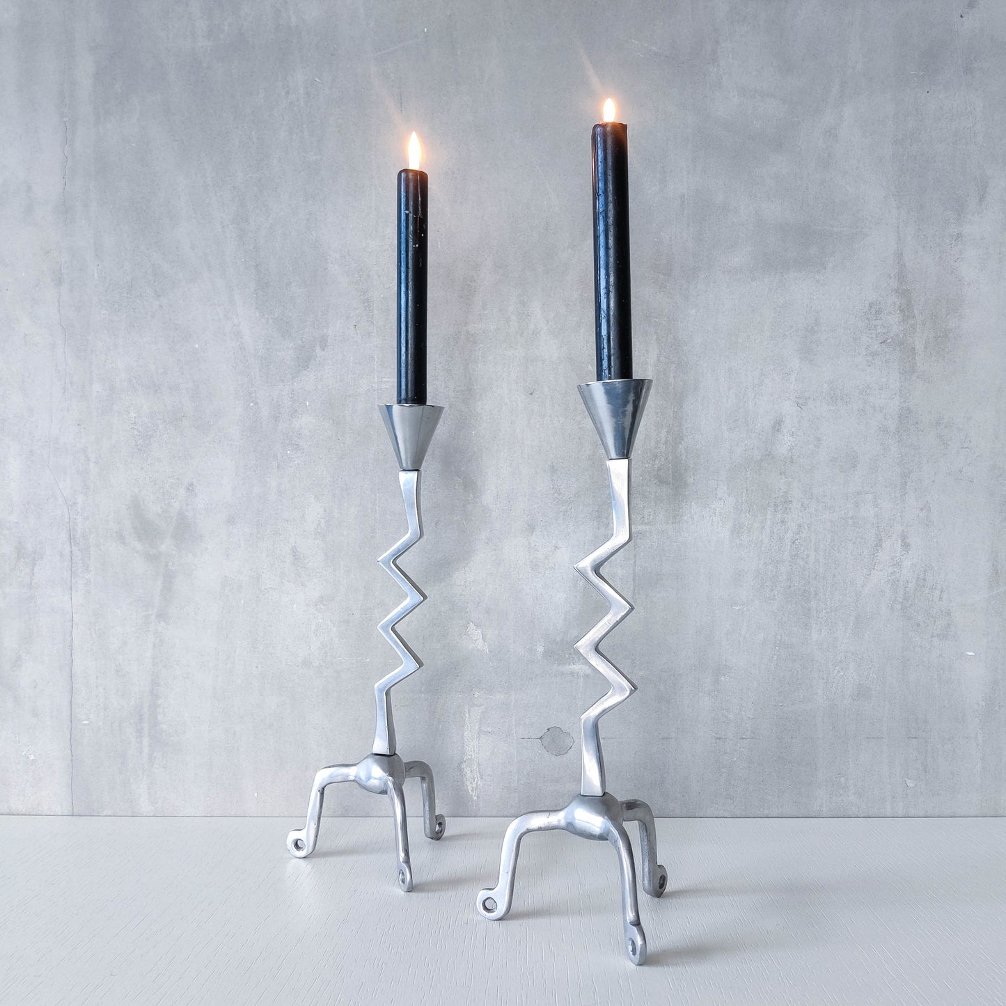 Pair of vintage postmodern chunky sculptural zigzag cast aluminium footed candle holders