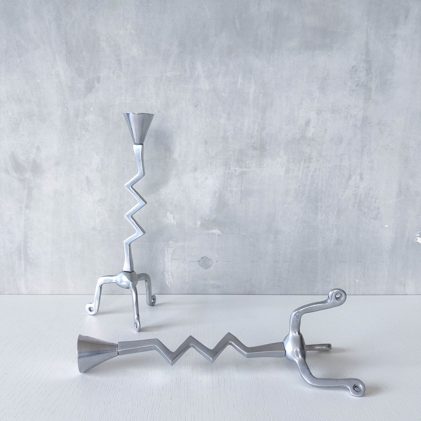 Pair of vintage postmodern chunky sculptural zigzag cast aluminium footed candle holders