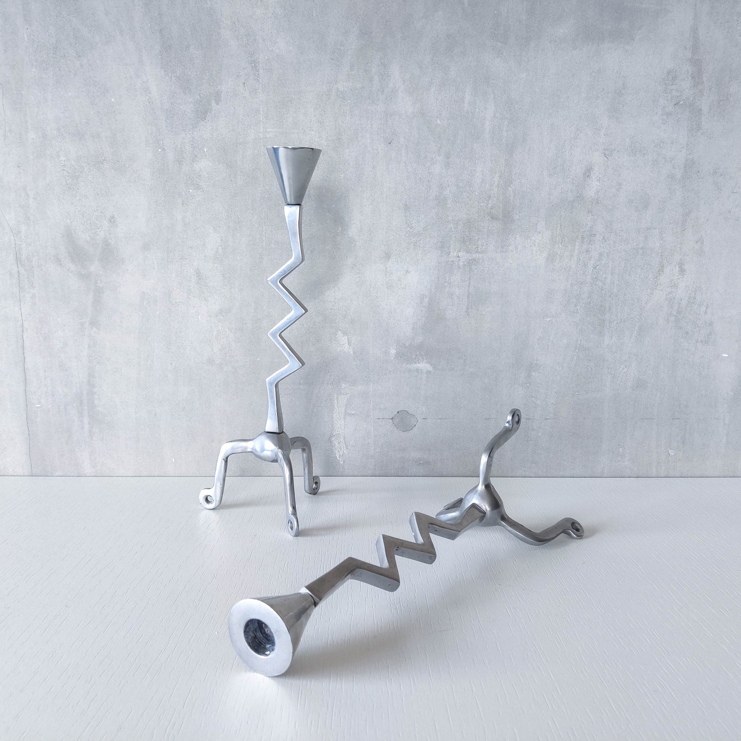 Pair of vintage postmodern chunky sculptural zigzag cast aluminium footed candle holders