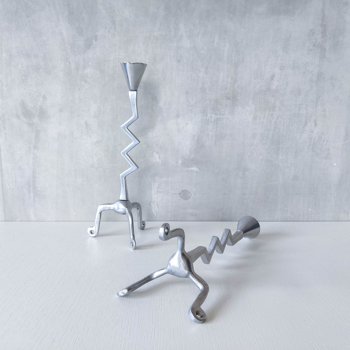 Pair of vintage postmodern chunky sculptural zigzag cast aluminium footed candle holders